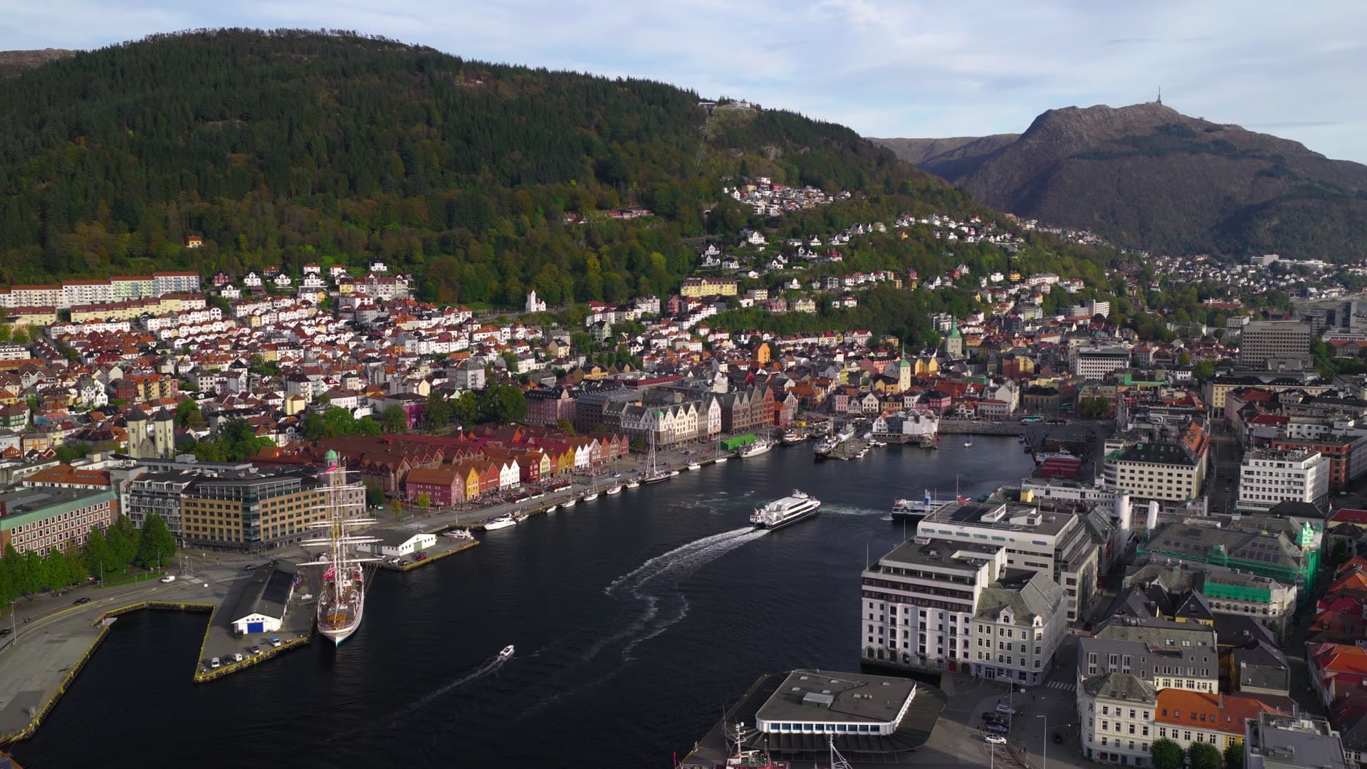Ferry vessel departing narrow fjord harbor, Bryggen, Bergen, Norway