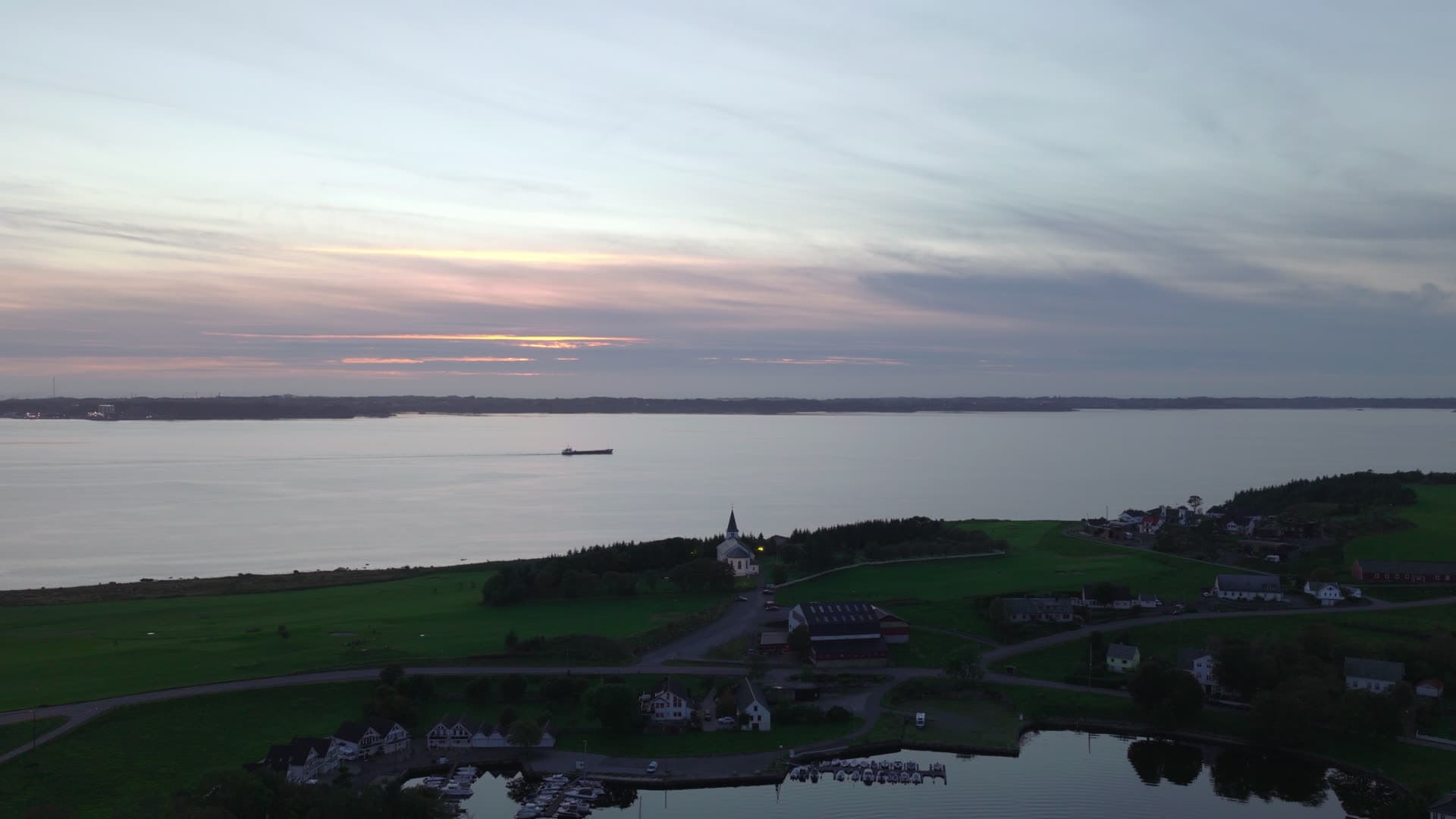 Coastal village at dawn with church and ship, Herdla