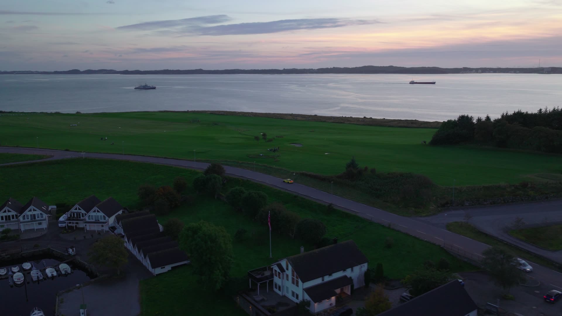 Coastal farmland with bay and vessels at dusk, Herdla
