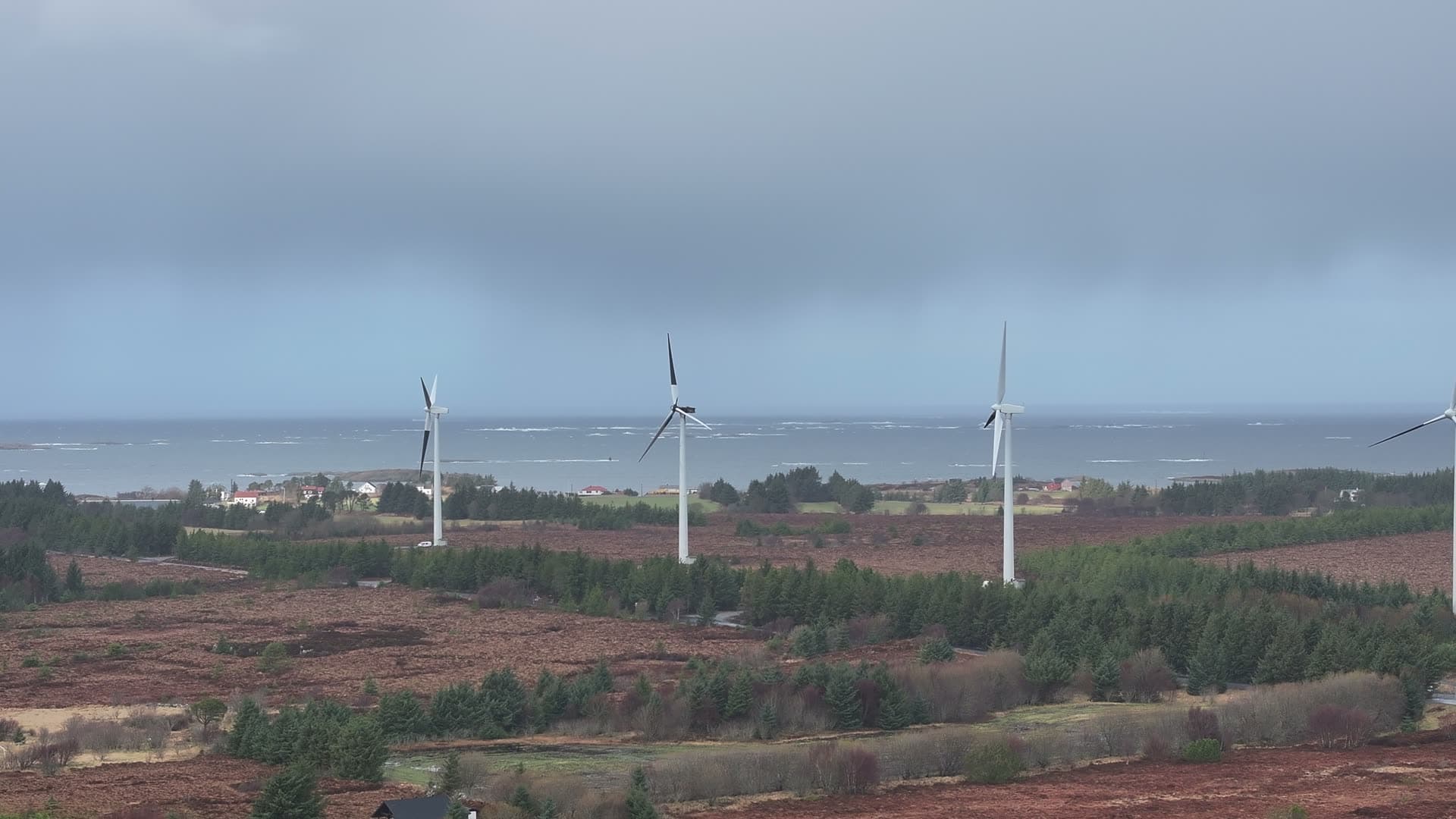 Wind turbines across coastal moorland on Harøy, Norway