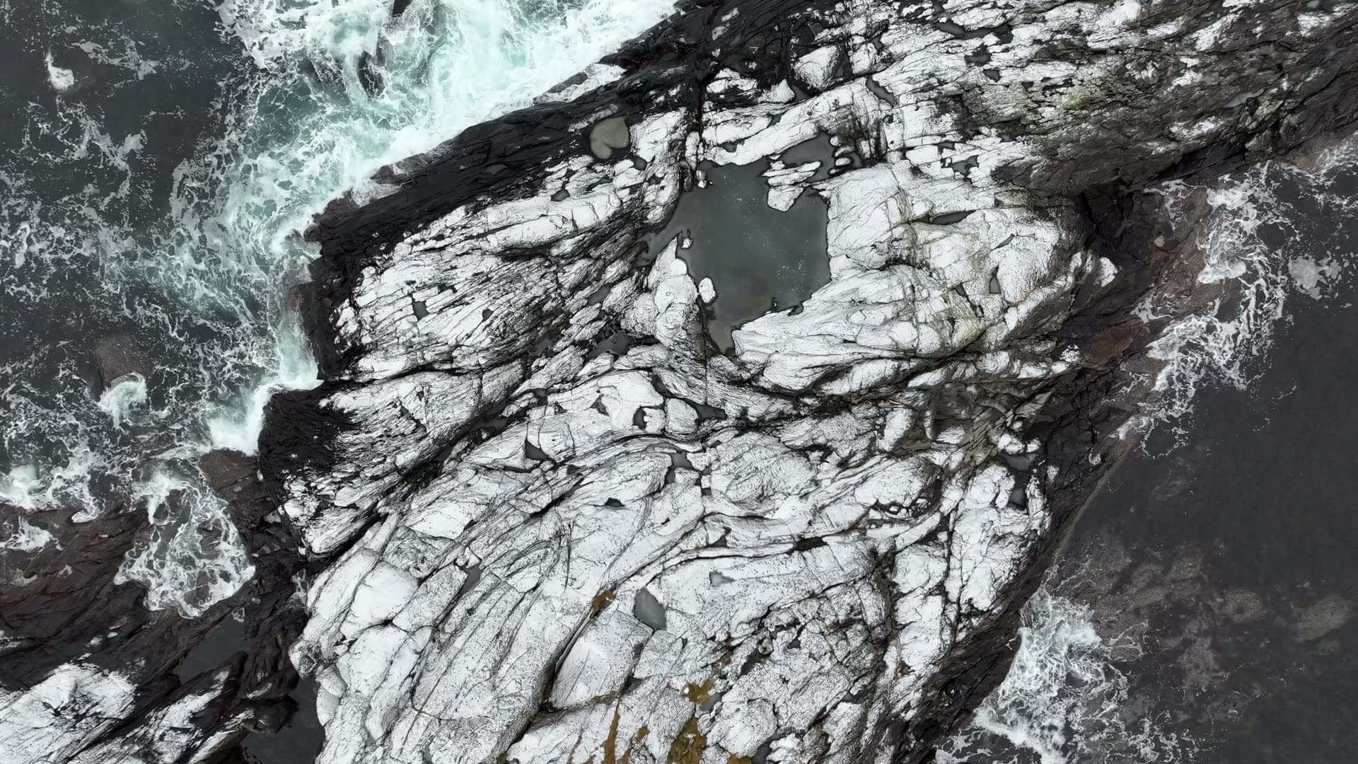 Winter waves washing over snow dusted coastal rocks at Ulla, Haramsøy
