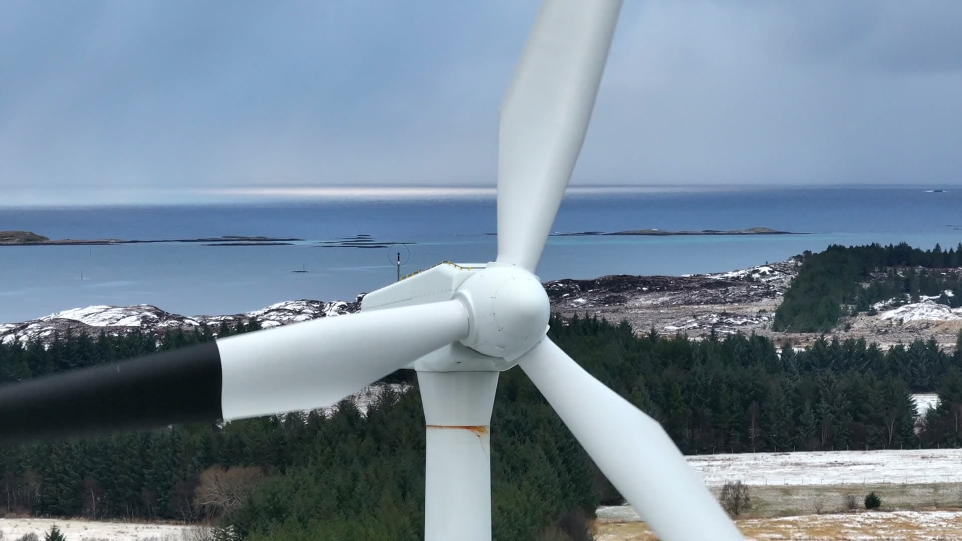 Close frontal view of rotating wind turbine blades by the coast, Harøy