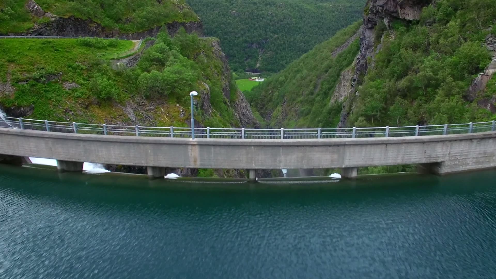 Drone crossing Zakariasdammen from reservoir to foaming spillway
