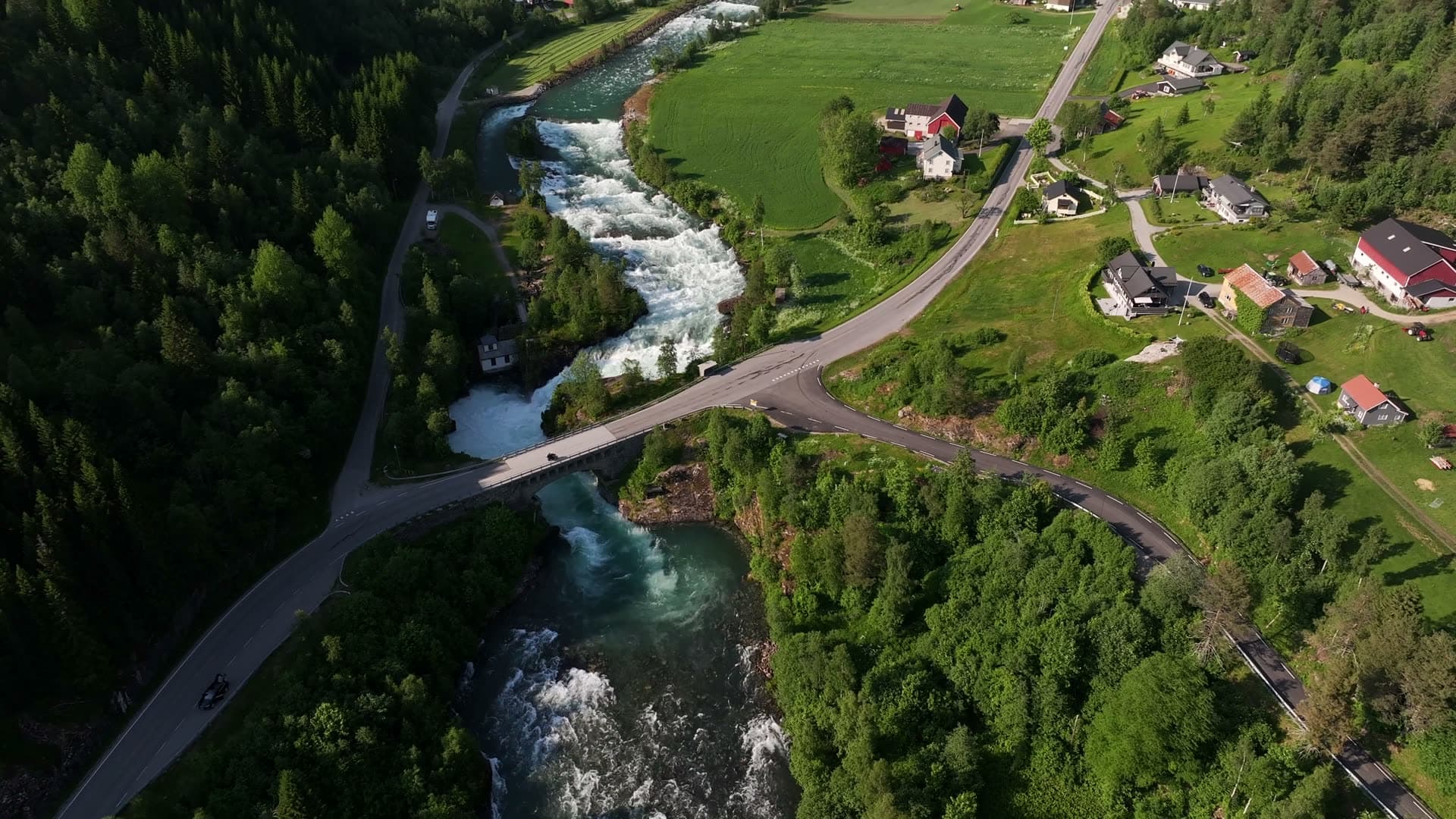 Rising aerial view of a bridge and rushing river in Valldal