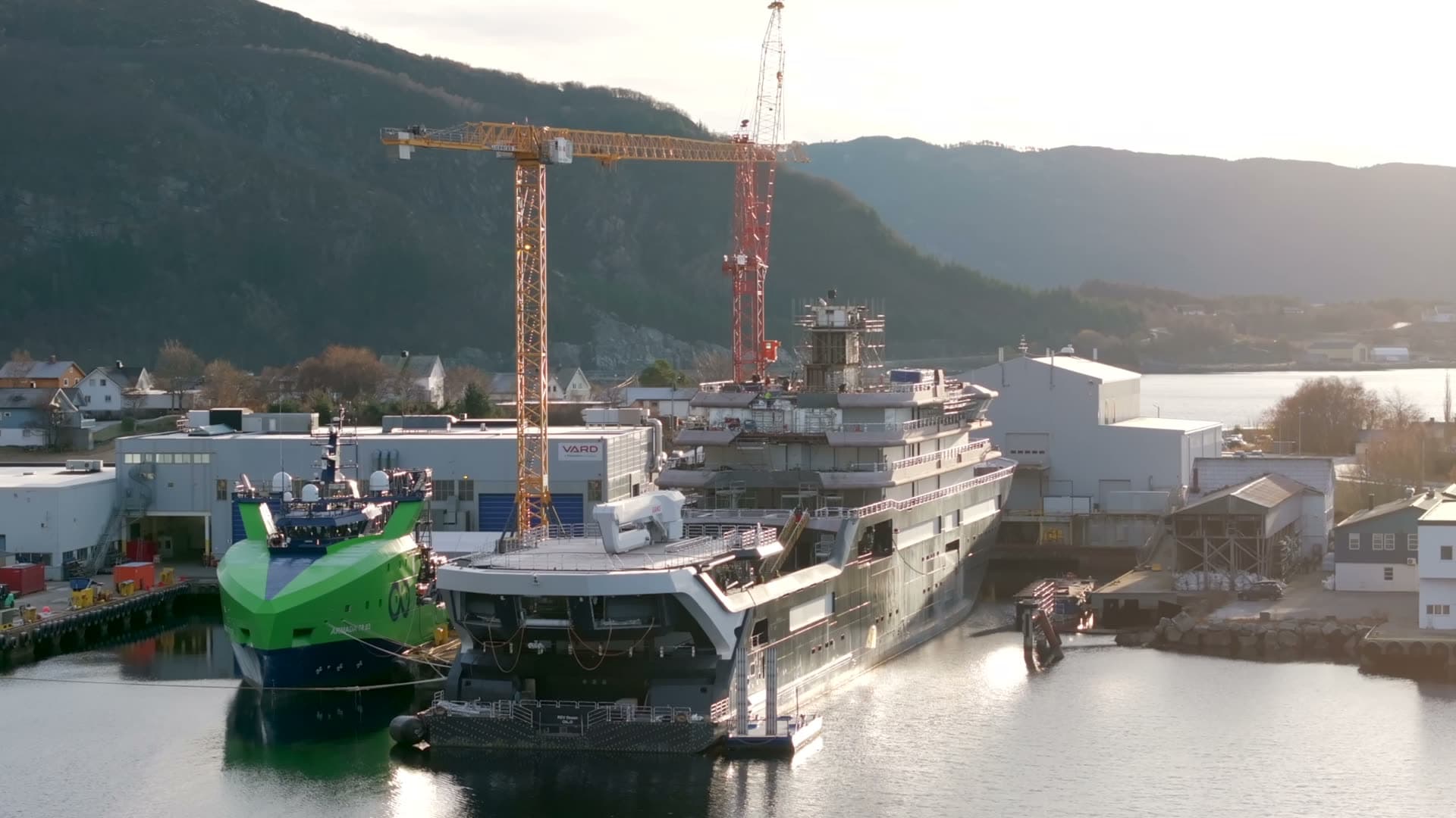 Rear aerial view of REV Ocean at the shipyard in low sunlight
