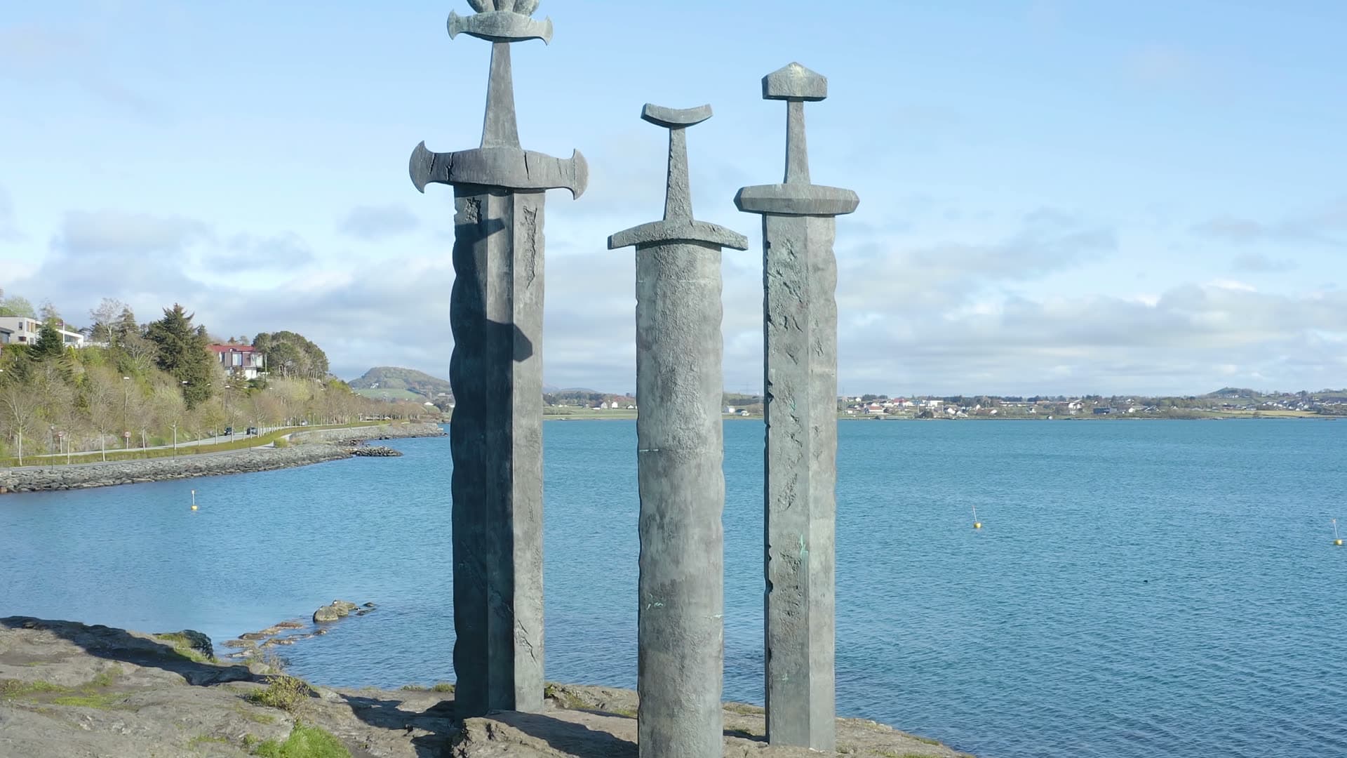 Three coastal stone crosses by water, Sverd i fjell