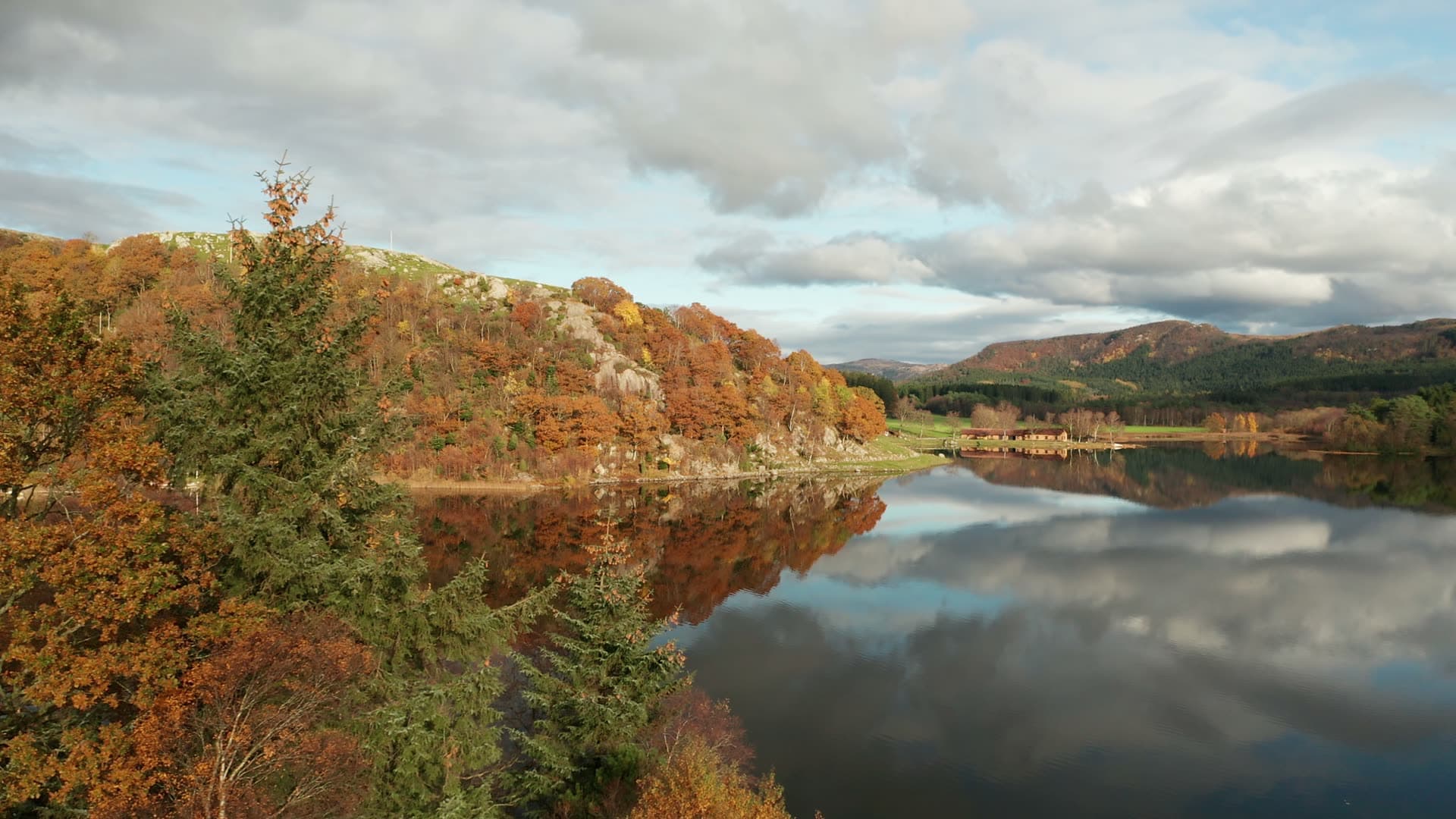 Forested hillside mirrored in lake water, Bråsteinvatnet