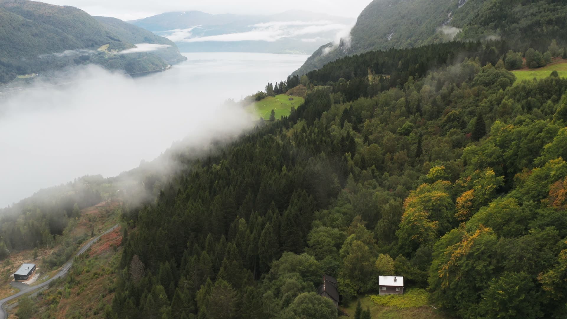 Misty mountain valley with remote houses, Innvikfjorden