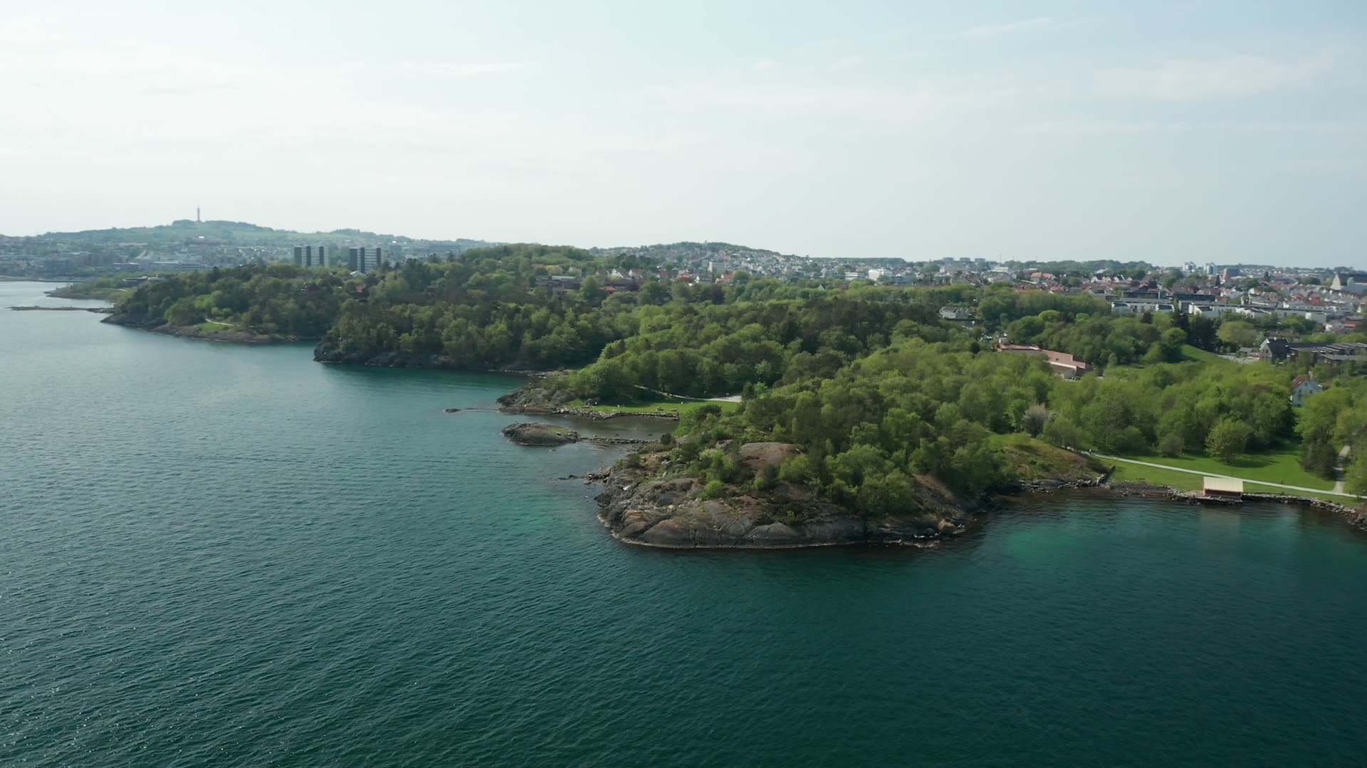 Rocky peninsula with lakeside suburban town, Stavanger