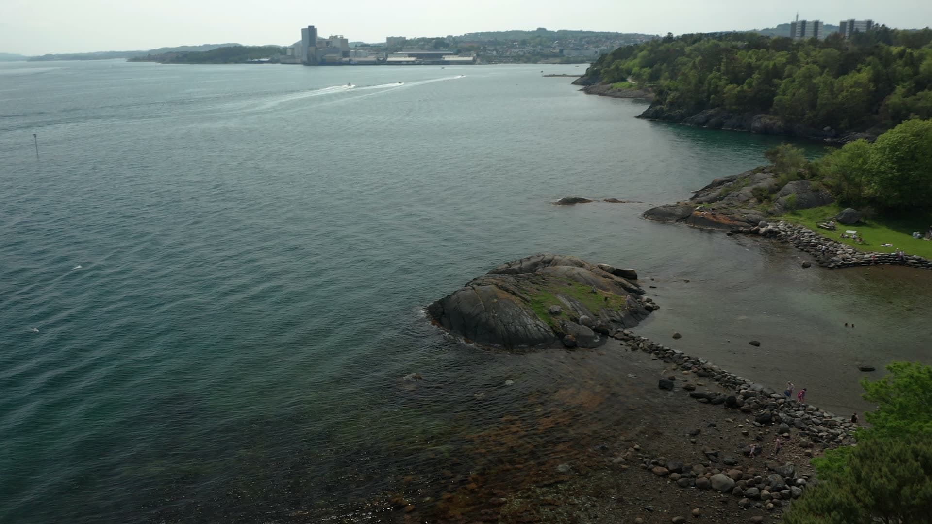 Rocky coastal outcrop with forested bay, Stavanger