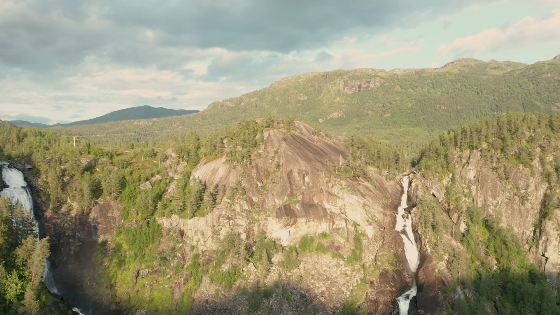 Twin waterfalls in forested mountain gorge, Låtefossen