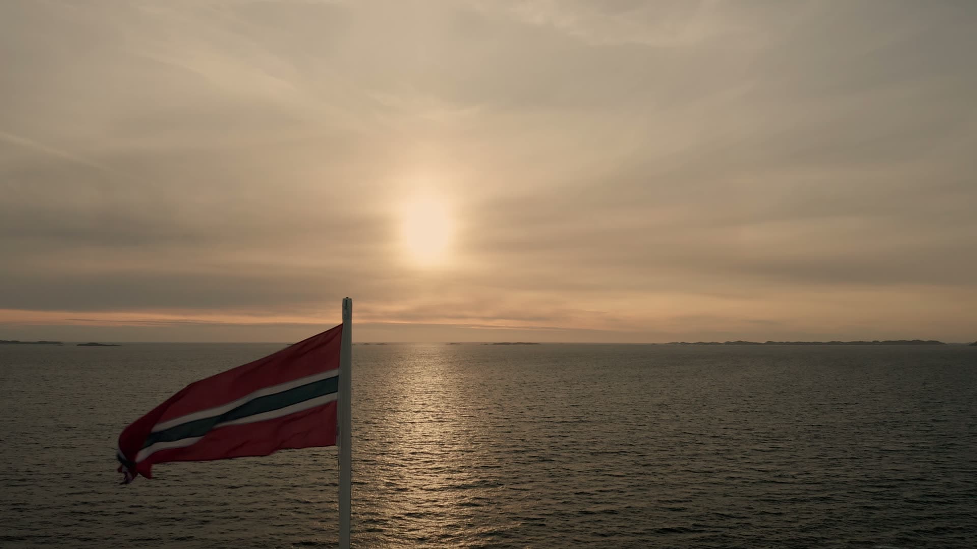 Norwegian flag at sunset over ocean, Ryvarden fyr