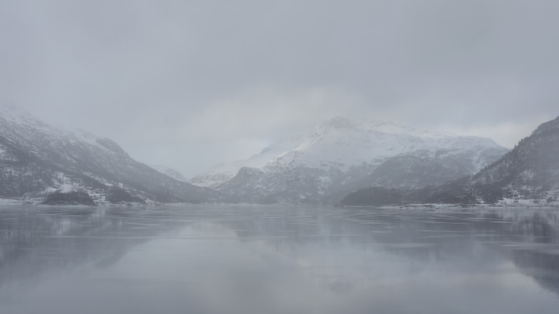 Frozen lake among snowy mountain peaks, Slettedalsvatnet