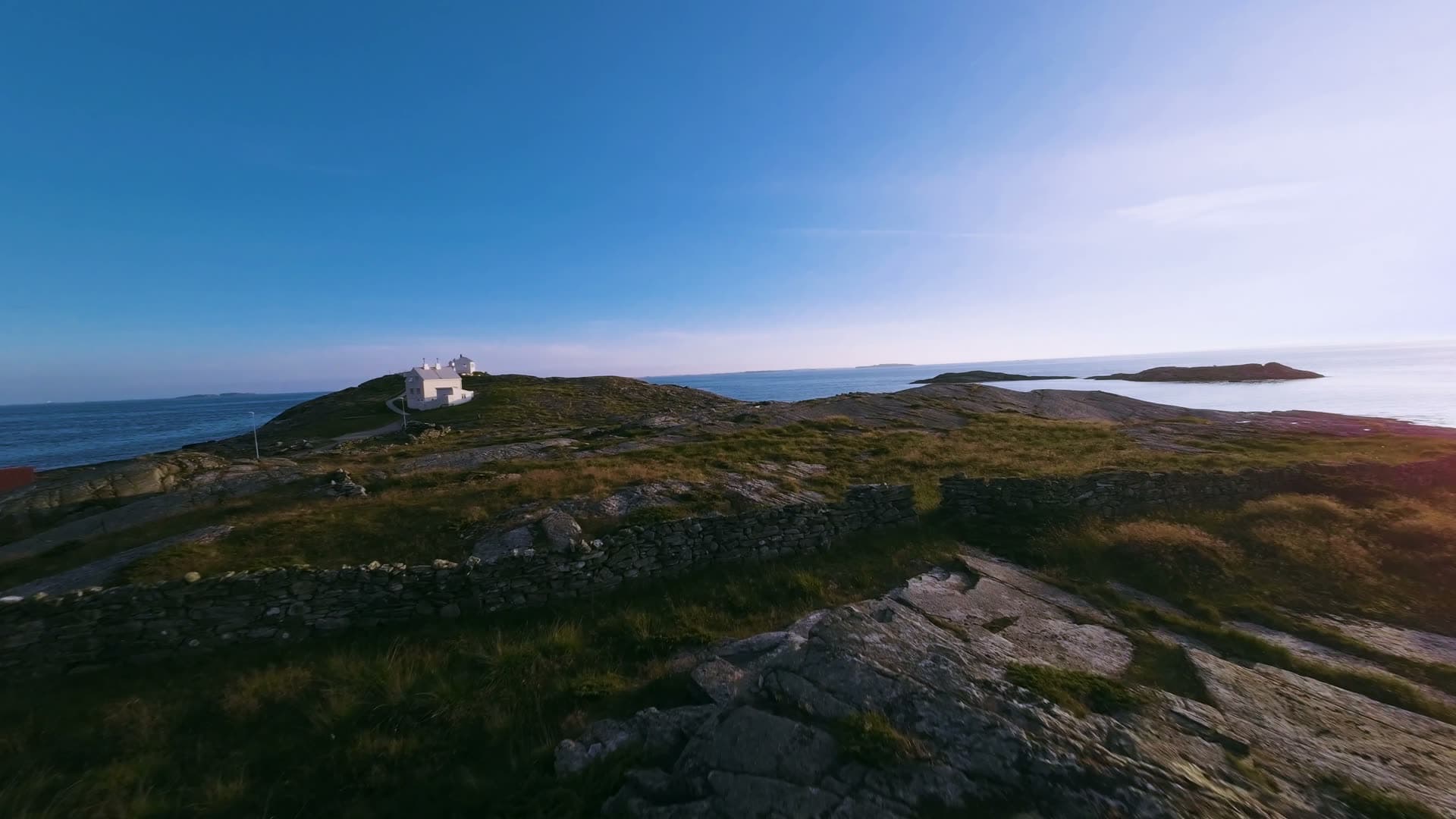 White lighthouse on rocky coastal headland, Fjøløy Fortress
