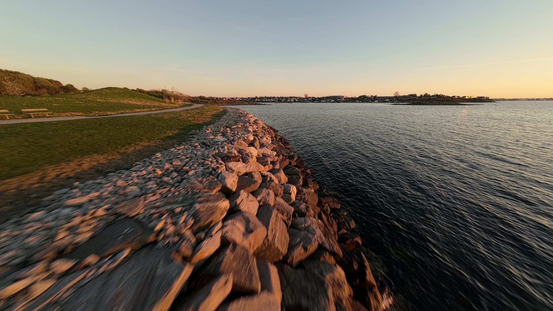 Rocky waterfront embankment at golden hour, Stavanger, Hundvåg dagturshytta