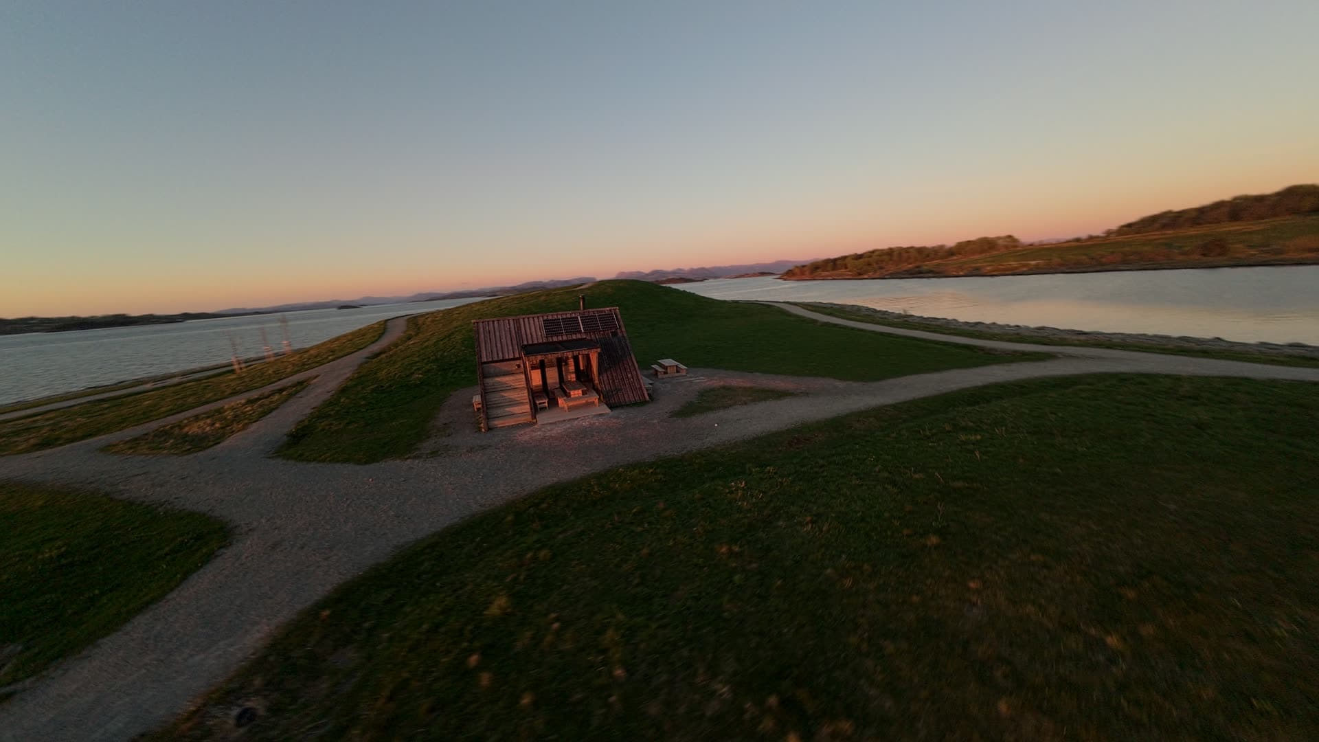 Coastal dike with lighthouse at sunset, Stavanger, Hundvåg dagturshytta
