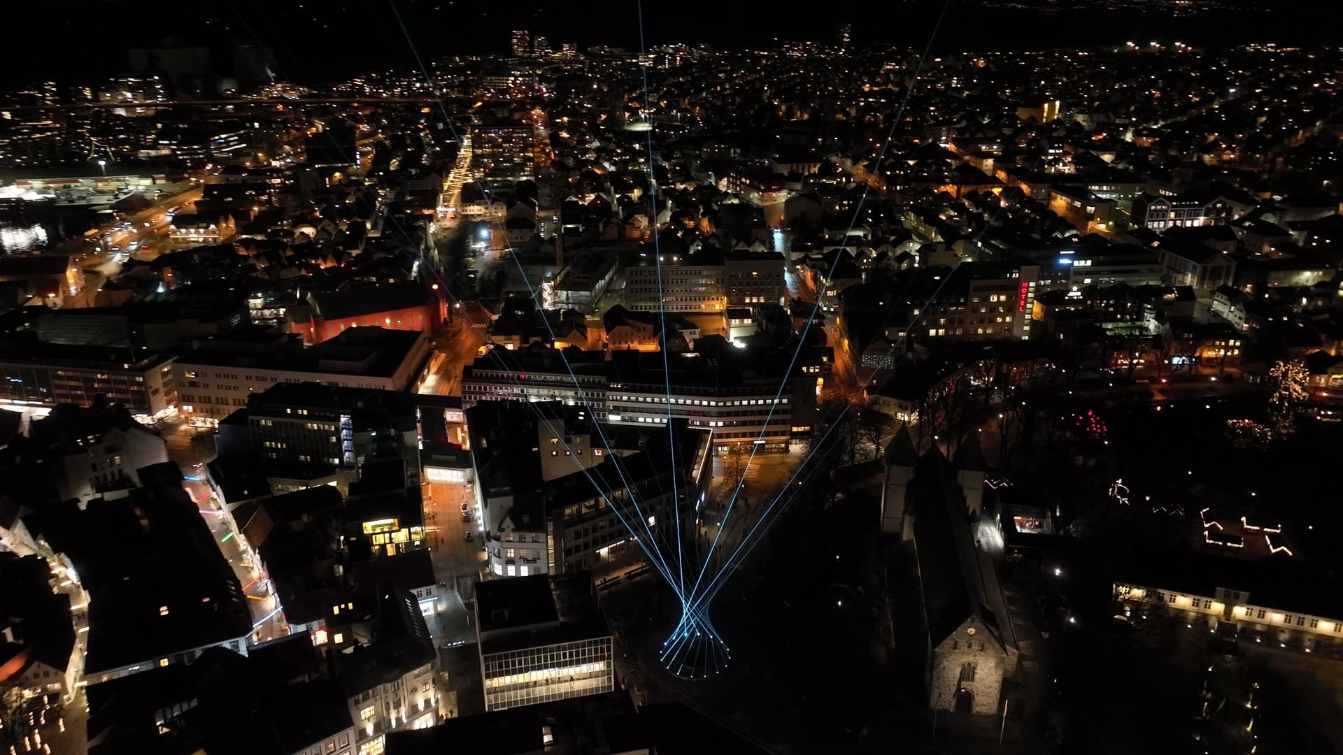 Blue light beams above city center at night, Stavanger, Glød