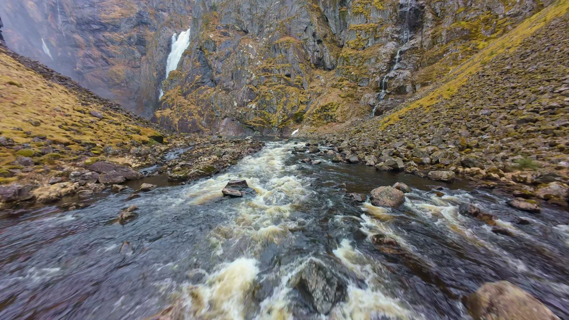 River flowing through mountain gorge to a big waterfall