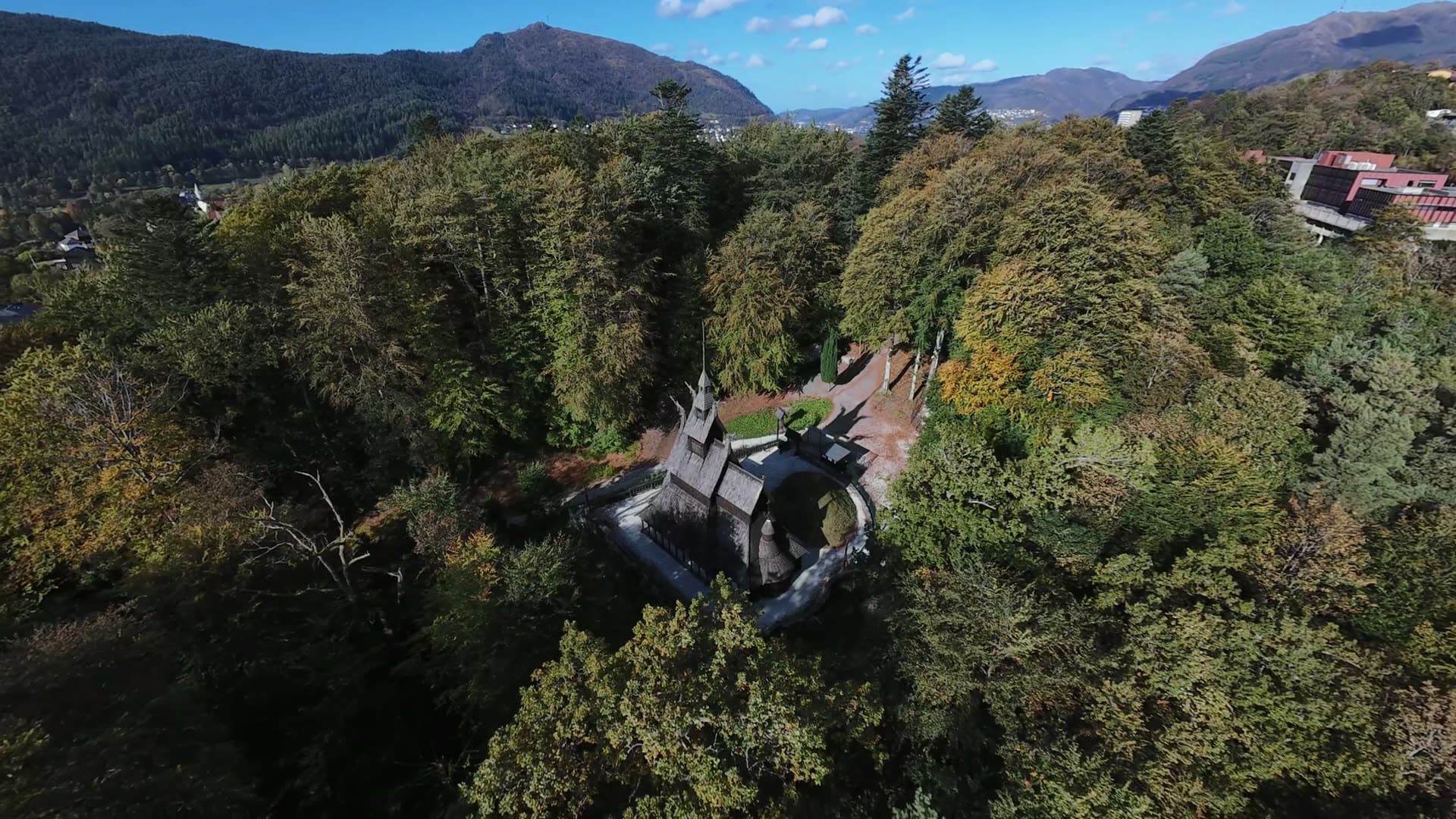 Medieval castle ruins in forested valley, Fantoft stavkirke