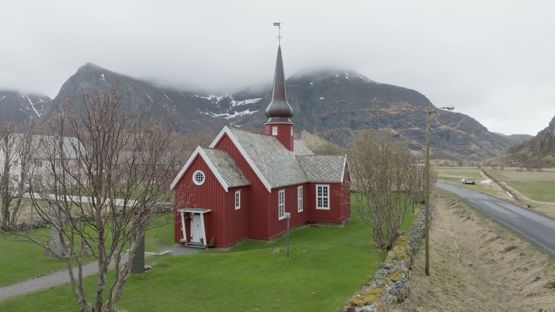Red wooden church in mountain valley, Flakstad kirke