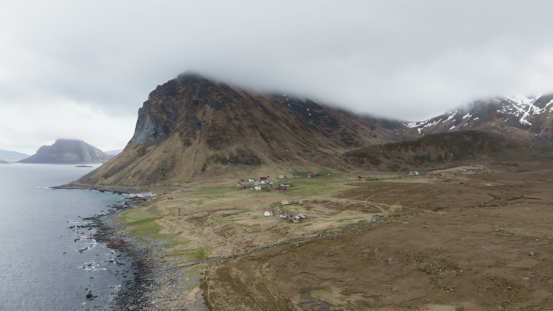 Remote village beneath volcanic cone, Myrland