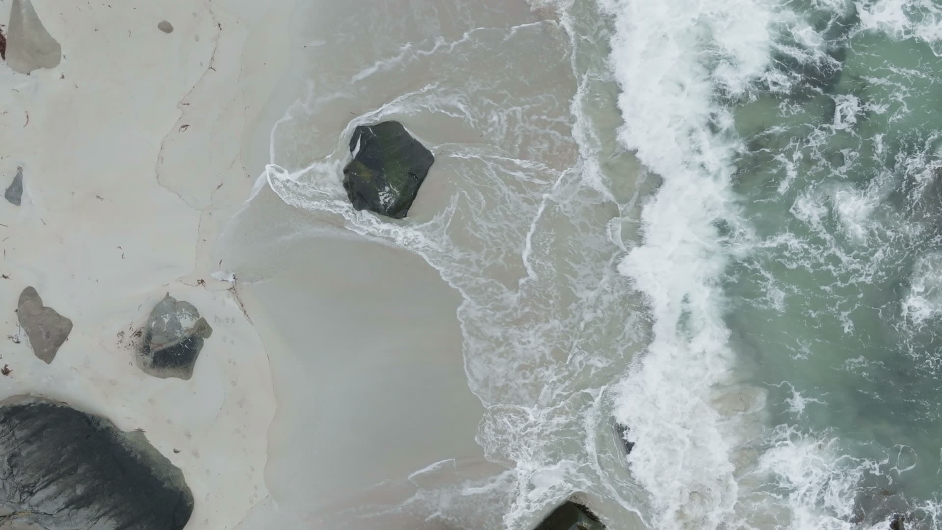 Waves and boulders on sandy beach, Myrland