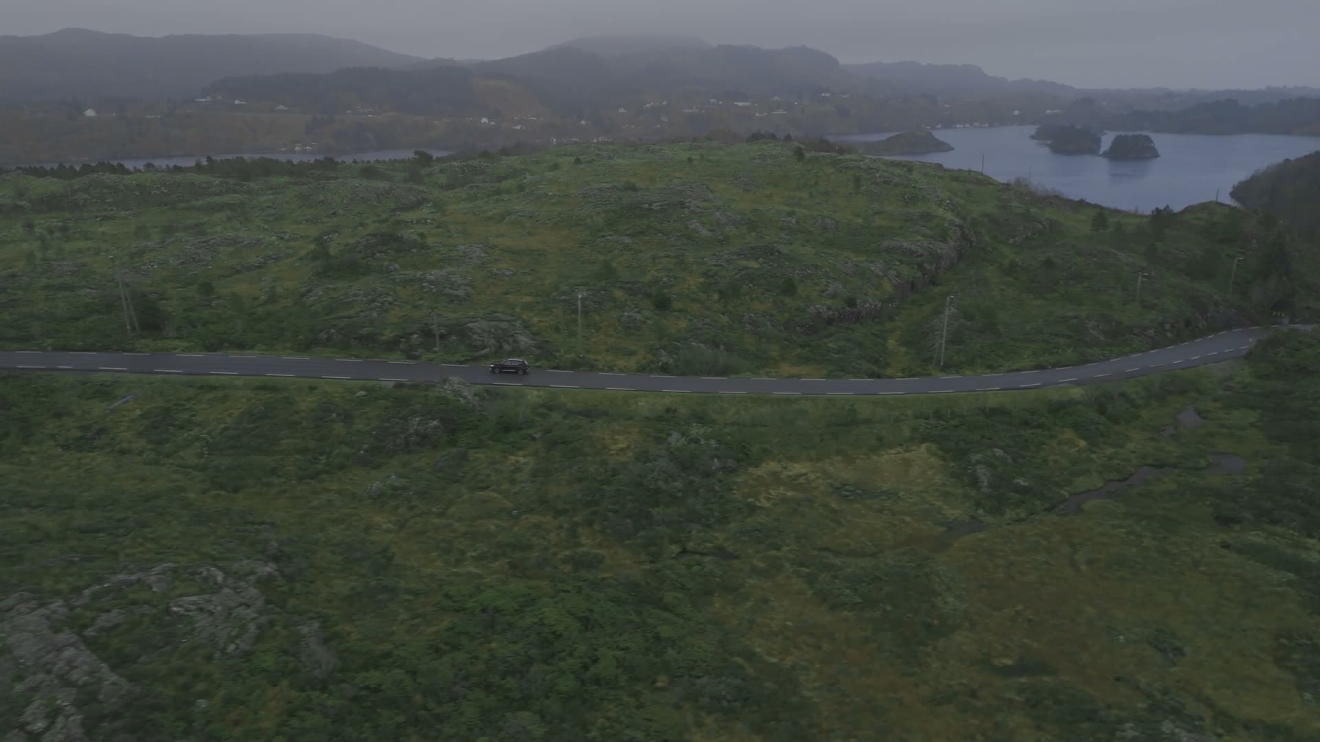 Winding mountain road through green hills, Glesvær