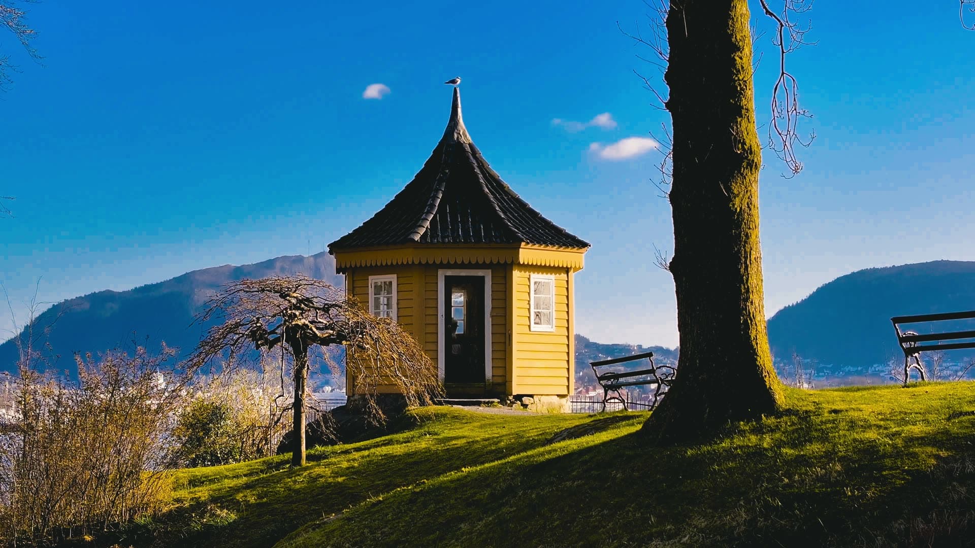 Yellow pavilion overlooking fjord and mountains, Bergen