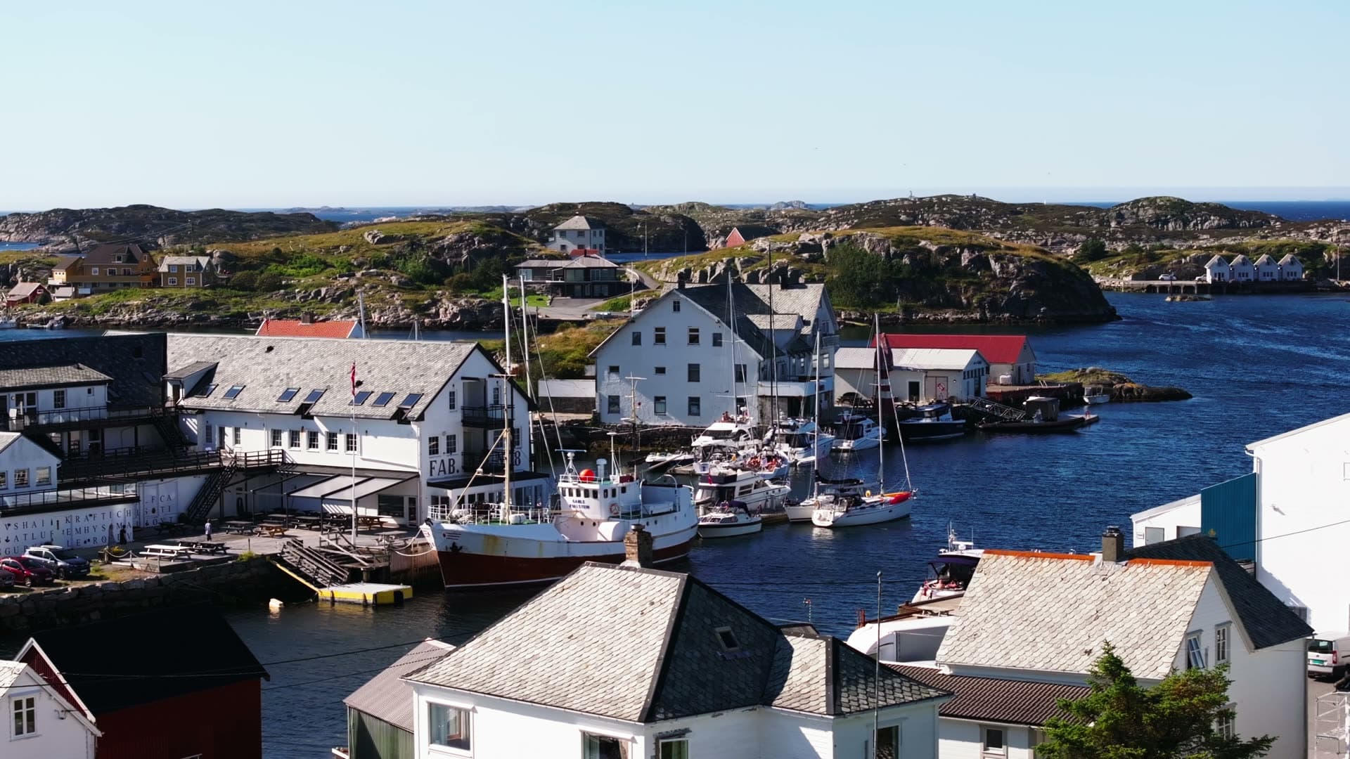 Working fishing harbor with moored boats and waterfront buildings, Fedje