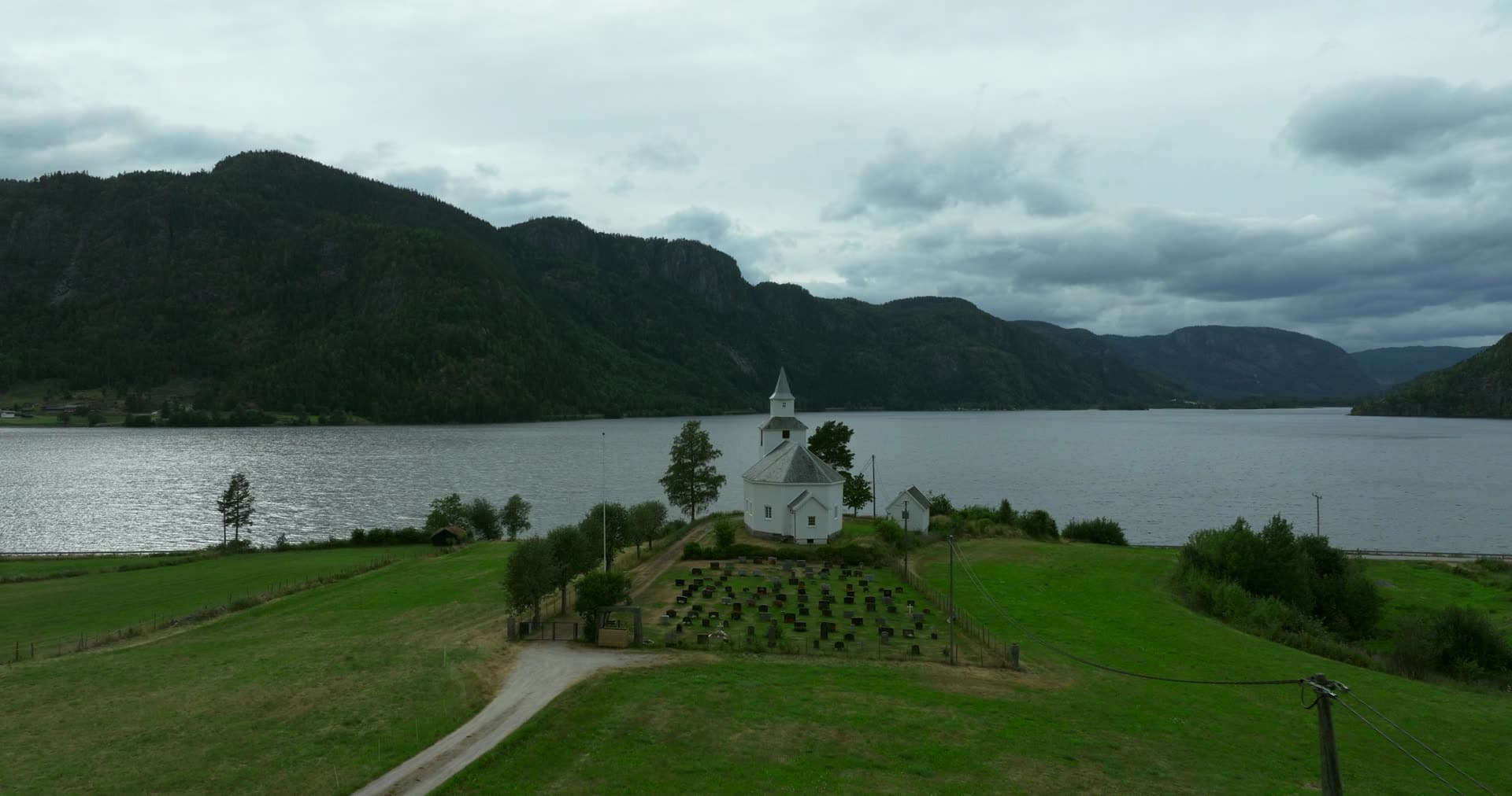 White church and graveyard by the lake, Åraksbø, Norway