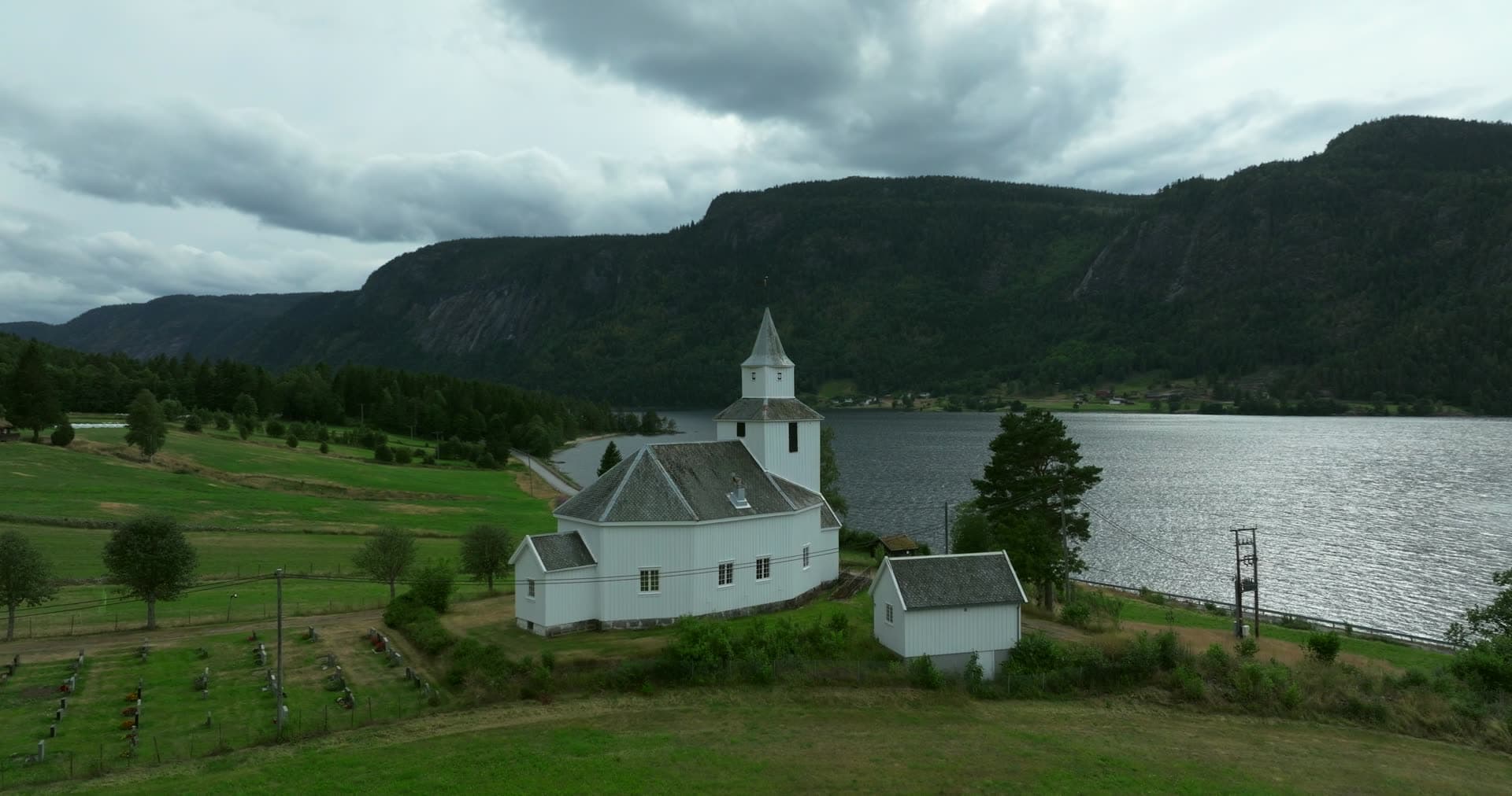 White church and graveyard by the lake, Åraksbø, Norway