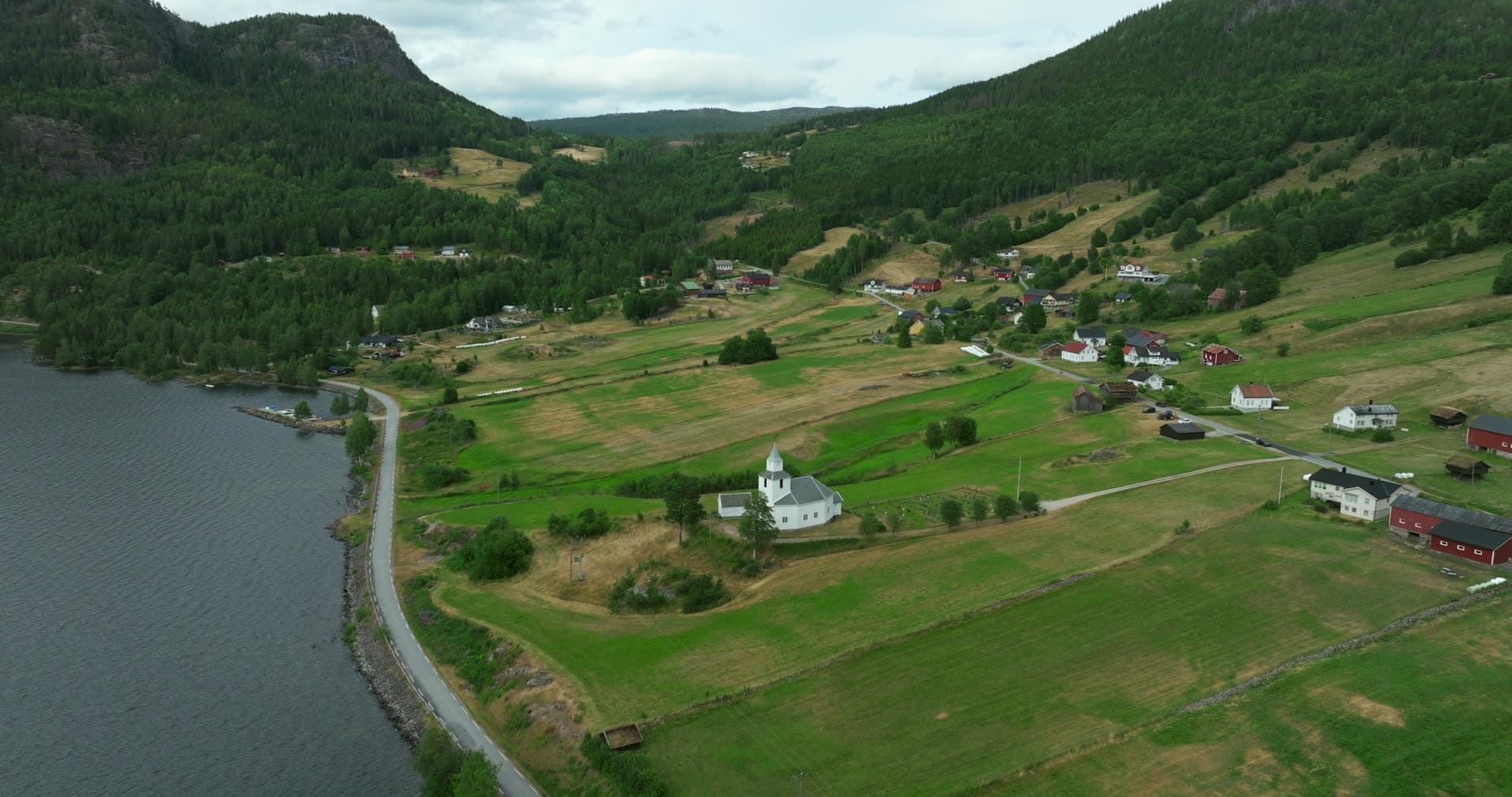 White church on lakeside farm fields, Åraksbø, Norway