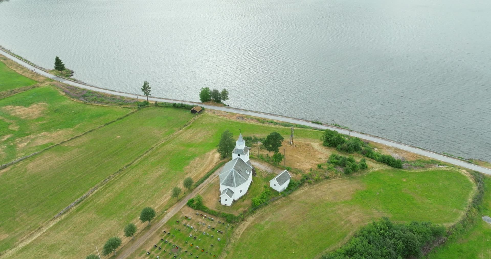 White church and graveyard by the lakeside road, Åraksbø, Norway