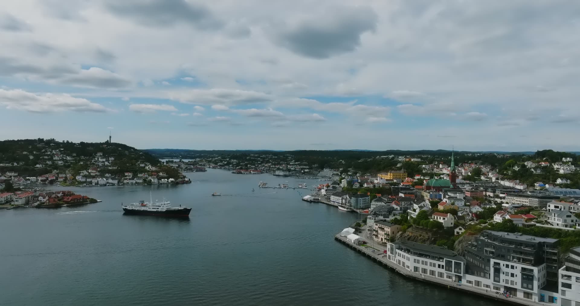 Black steamship passing town waterfront, Arendal, Norway