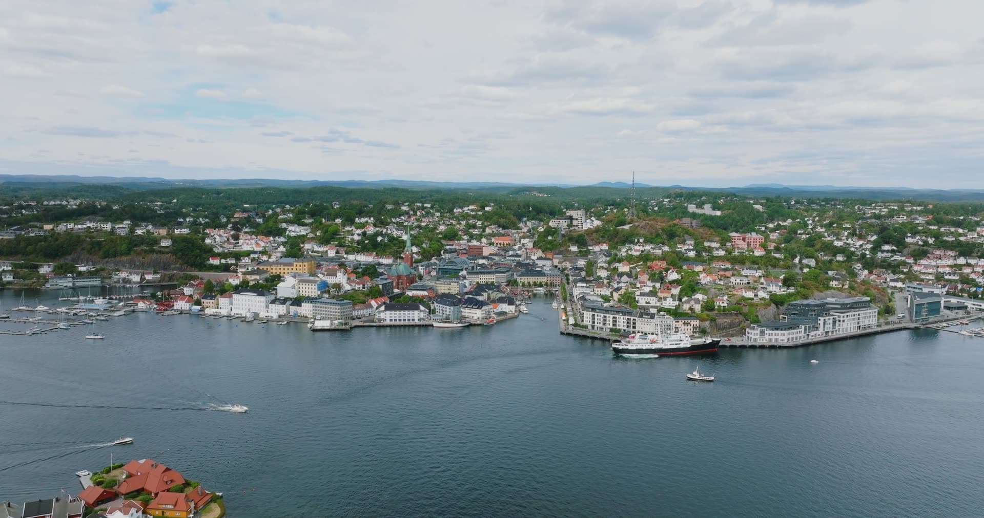 Cargo ship at quay and speedboats in harbour, Arendal, Norway