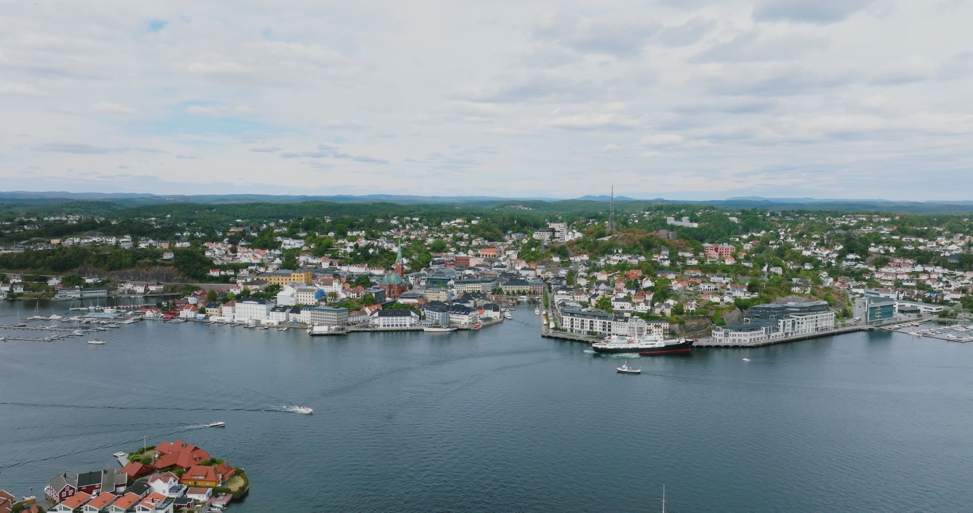 Cargo ship at quay and boats crossing the harbour, Arendal, Norway
