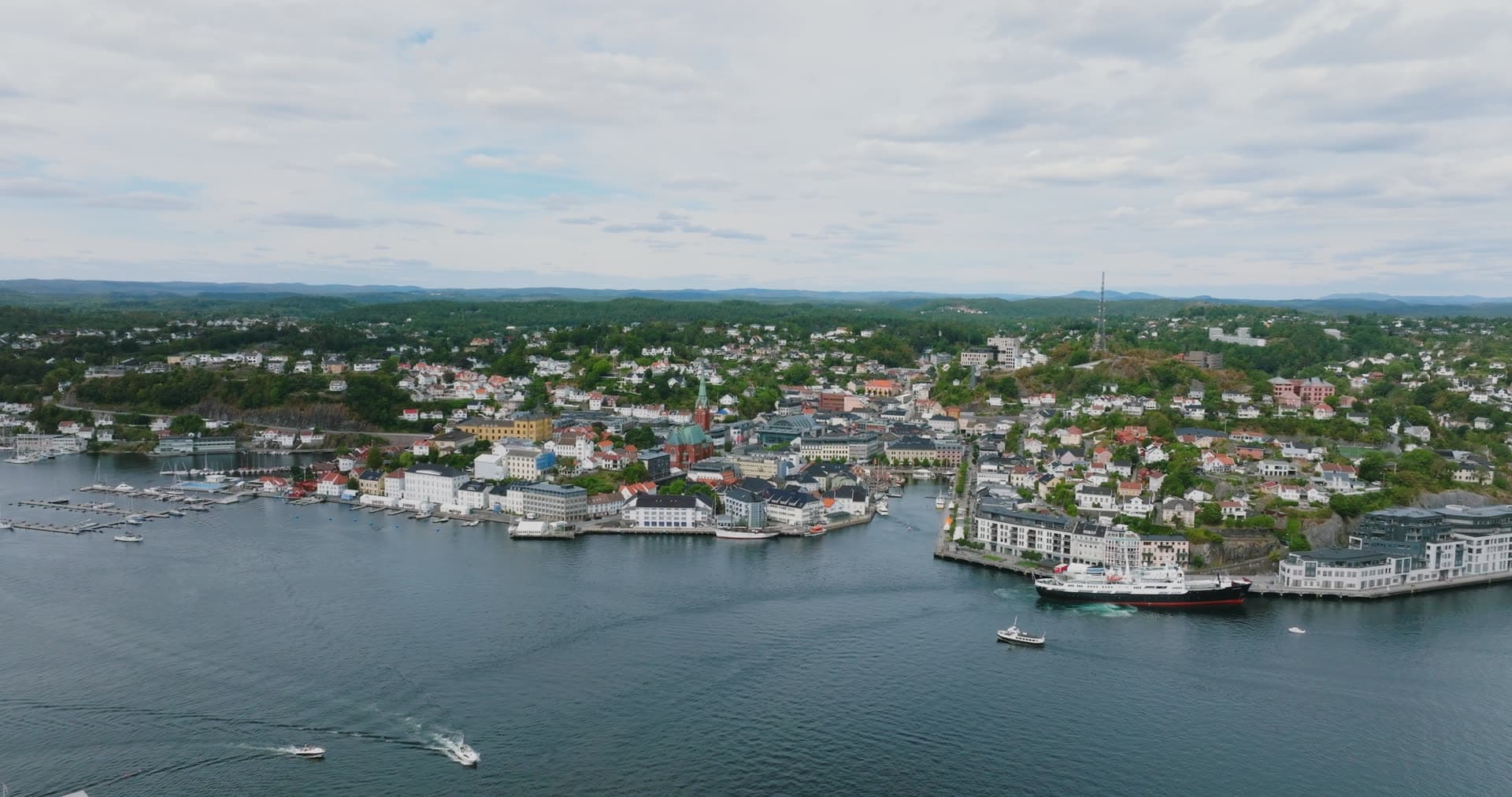 Cargo ship at quay and boats crossing harbour, Arendal, Norway