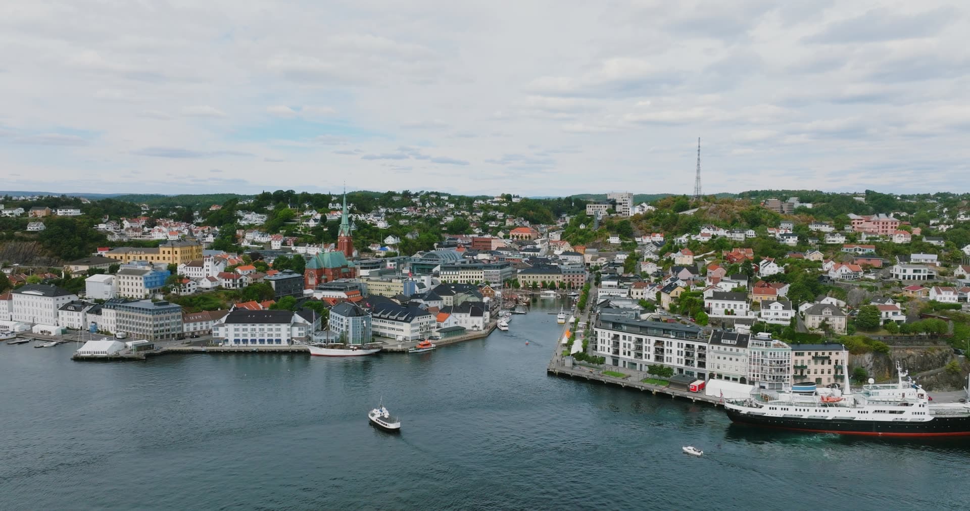 Passenger ship at quay and small boat in harbor, Arendal, Norway