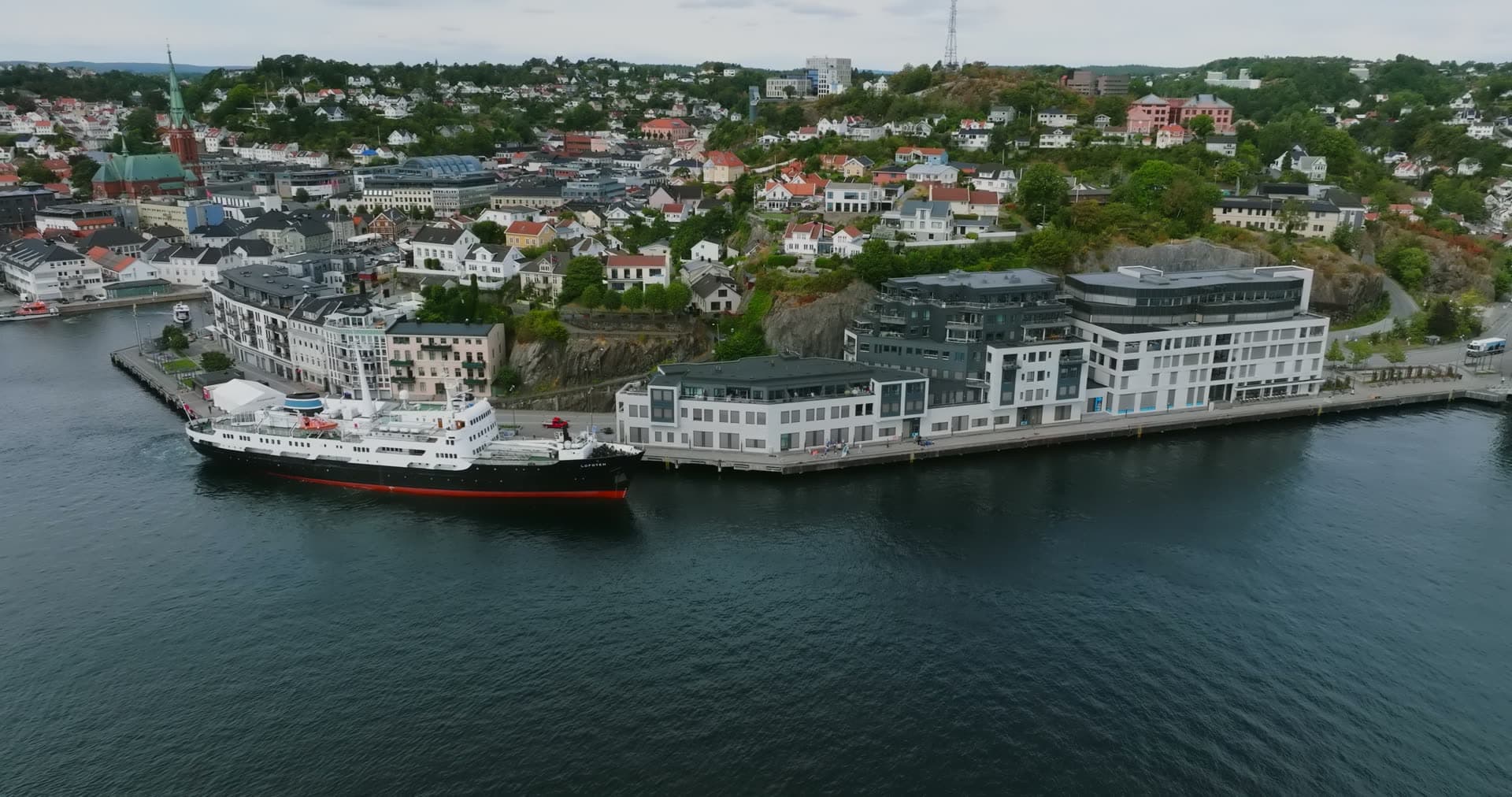 Passenger ship moored at waterfront apartments, Arendal, Norway