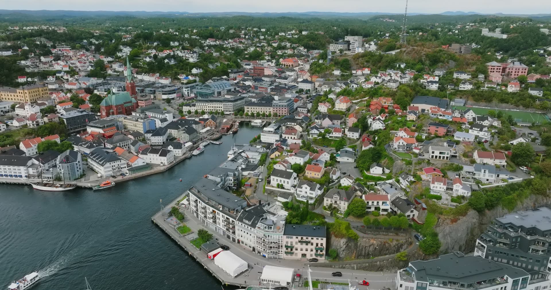 Church spire and harbour canal past Tyholmen rock, Arendal, Norway