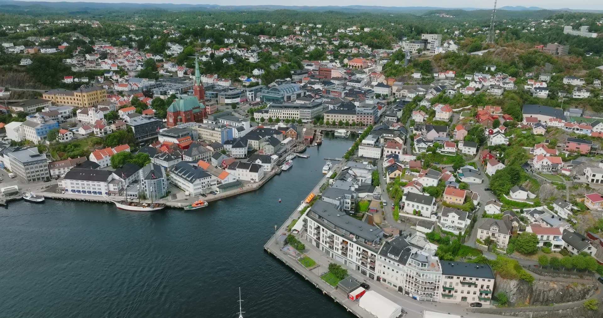 Green church spire and harbour channel, Arendal, Norway