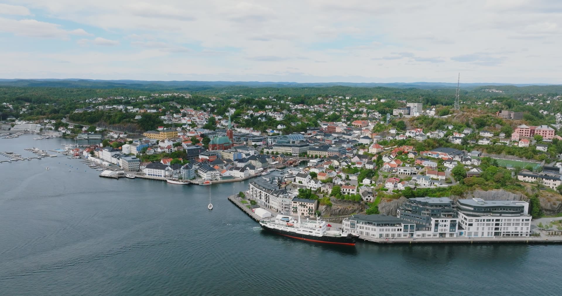 Ship moored at quay below town centre, Arendal, Norway