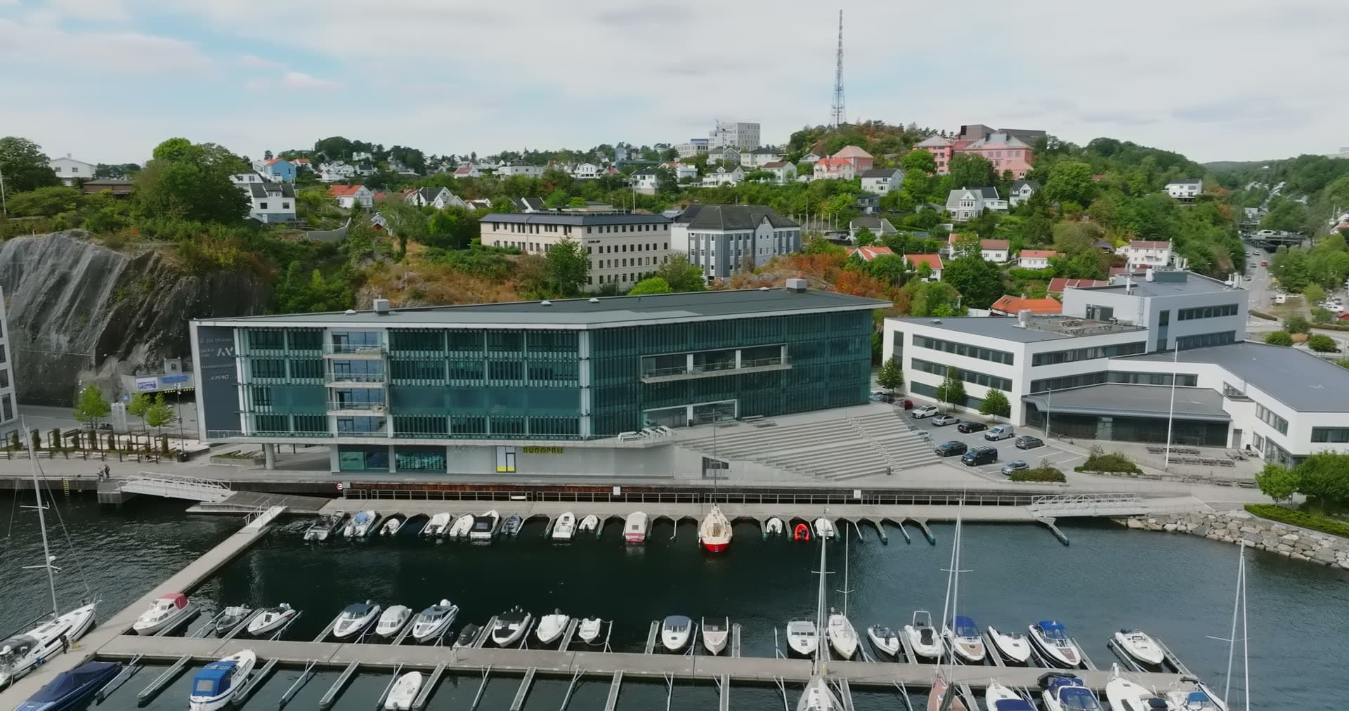Marina pontoons below glass office building, Arendal, Norway