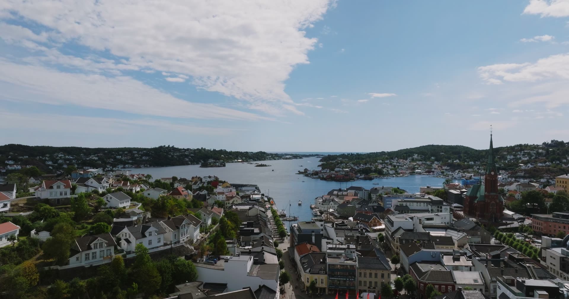 Church spire above town rooftops and harbour, Arendal, Norway