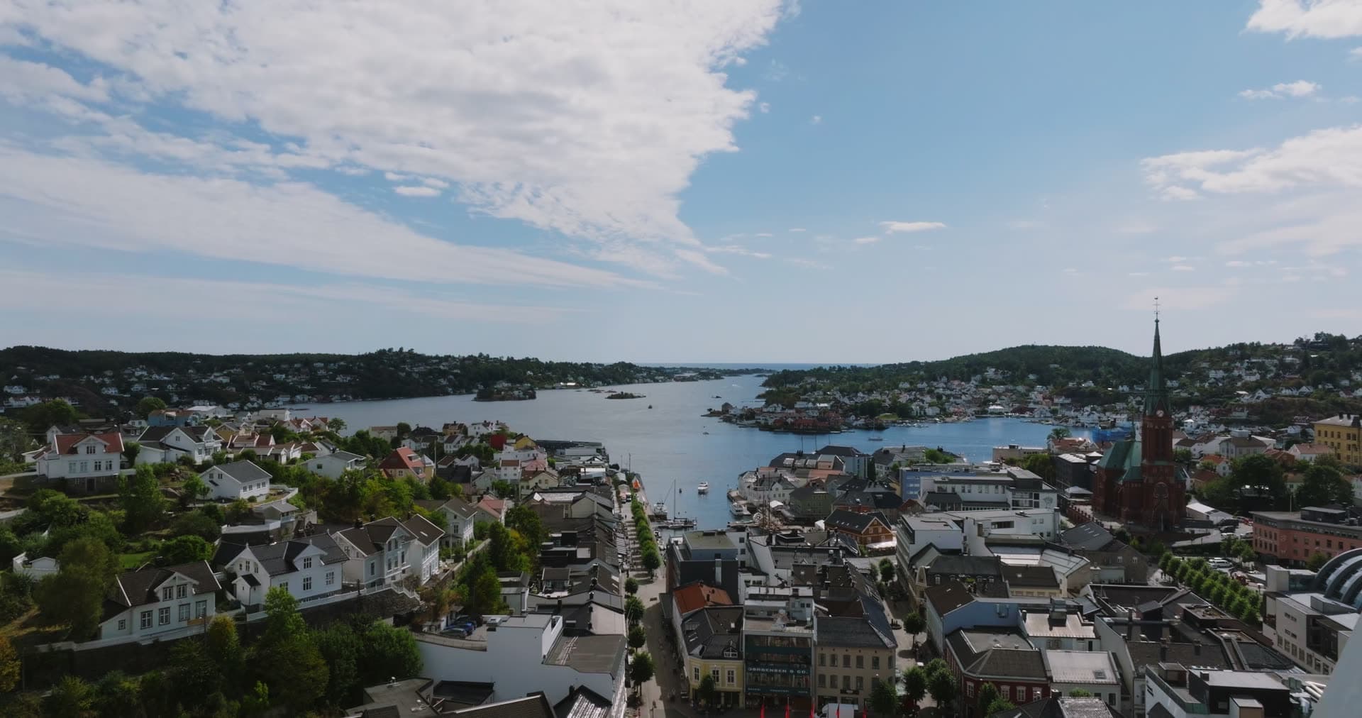Church spire and glass high-rise above the harbour, Arendal, Norway