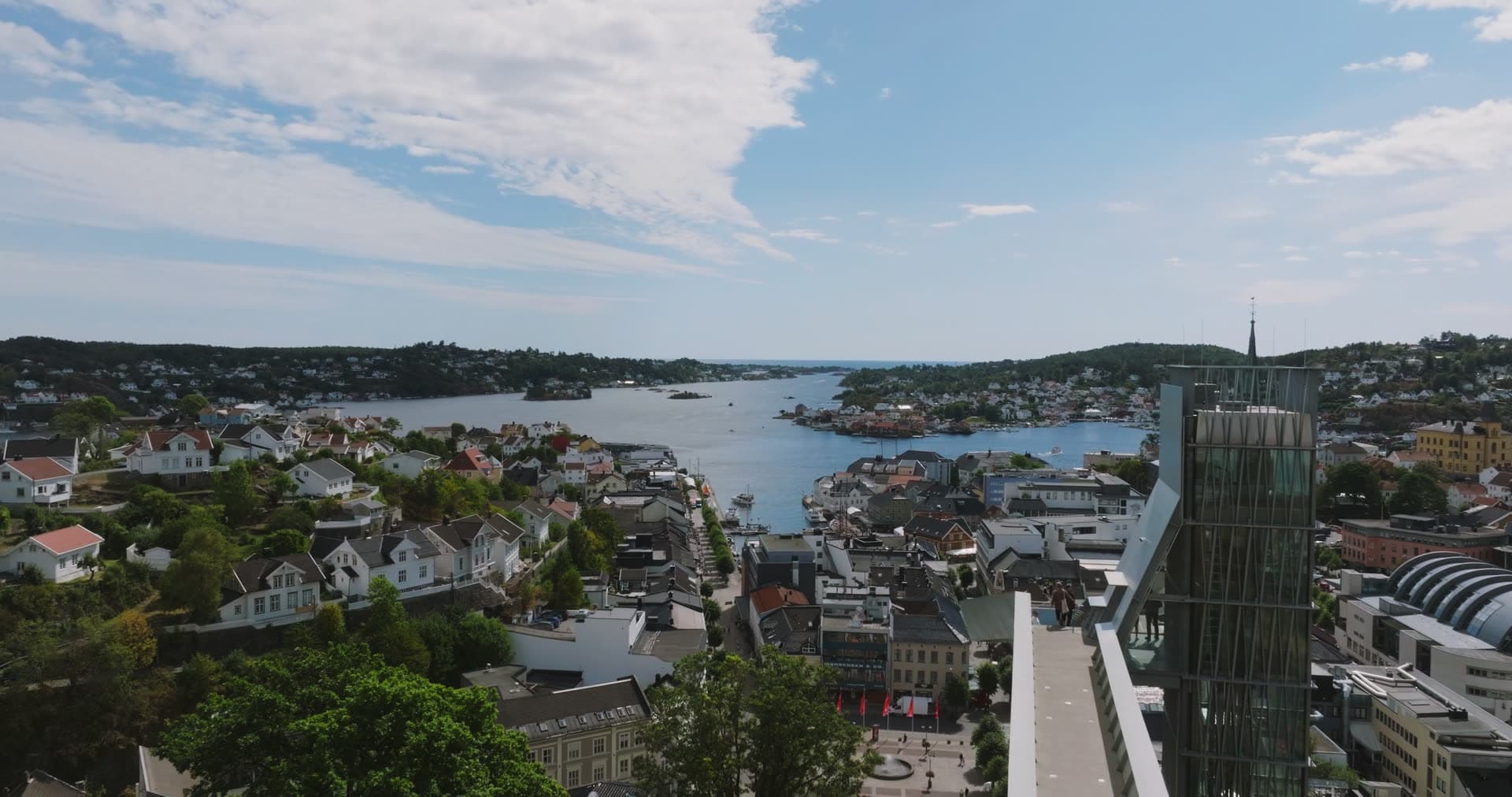 Glass high-rise and church spire above the harbour, Arendal, Norway