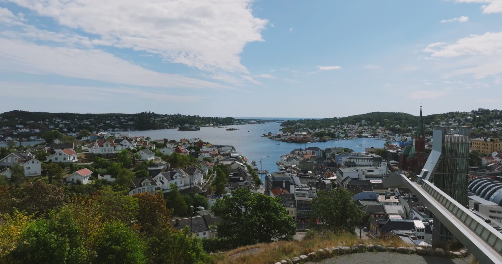 Hilltop view past church spire to harbour inlet, Arendal, Norway