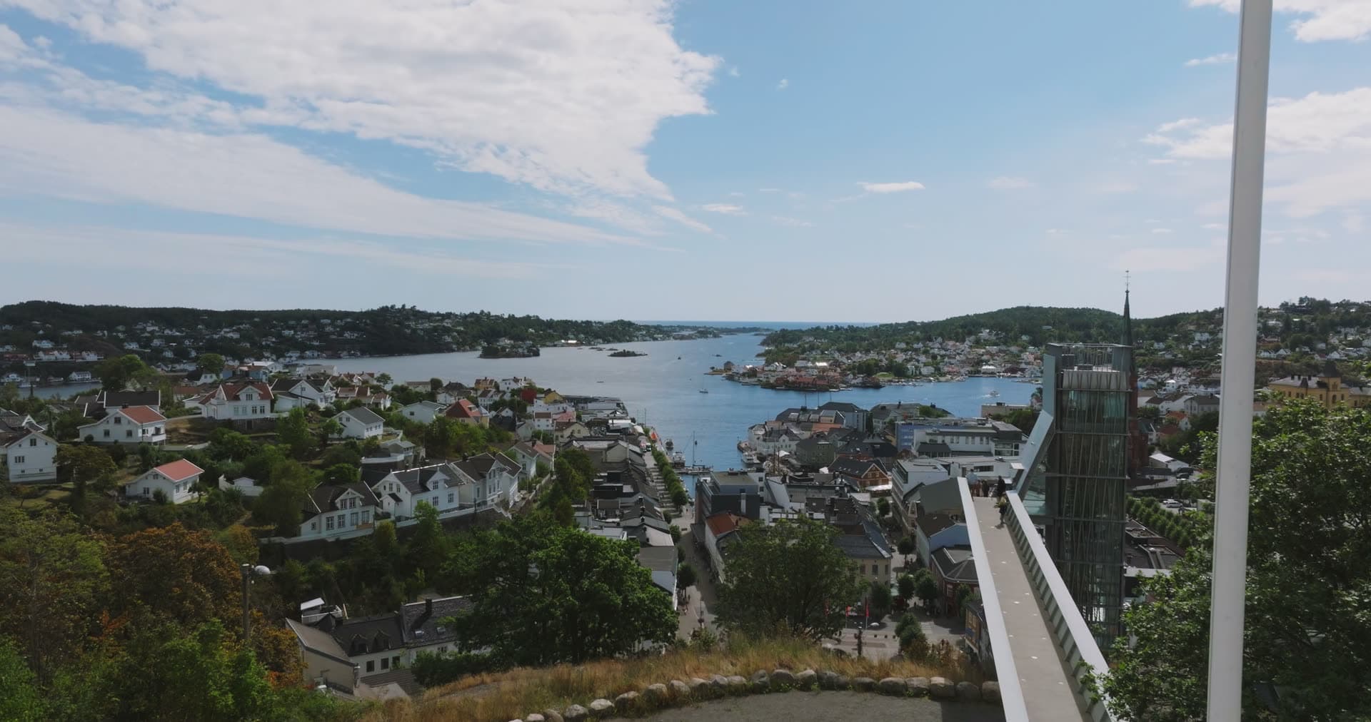 Hilltop viewpoint railing above white houses and harbor, Arendal, Norway