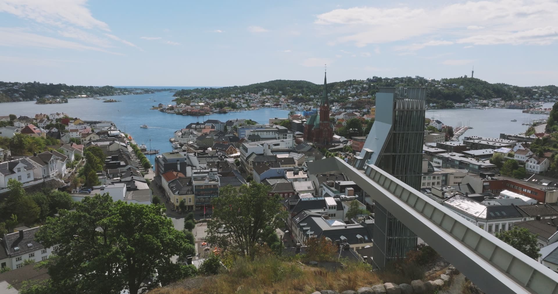 Hilltop glass elevator tower above town and church, Arendal, Norway