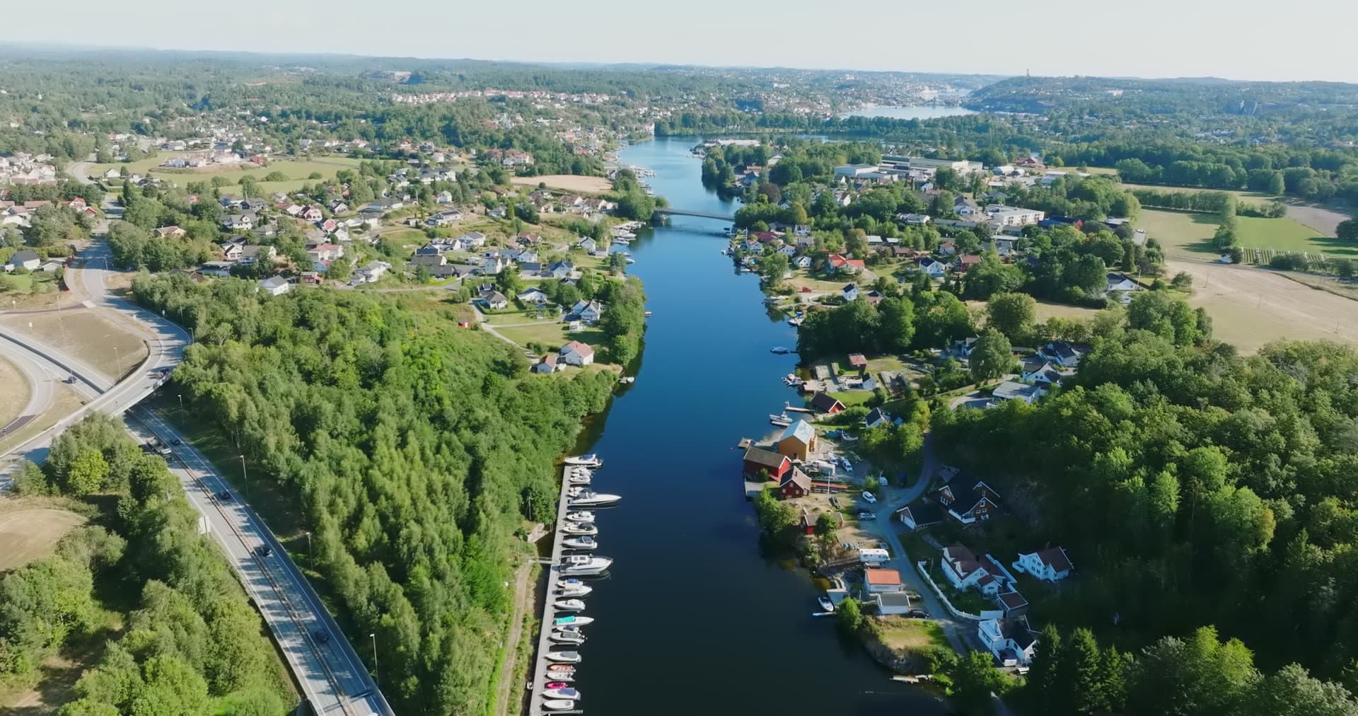 River canal with docked boats and highway, Bomsholmen, Norway